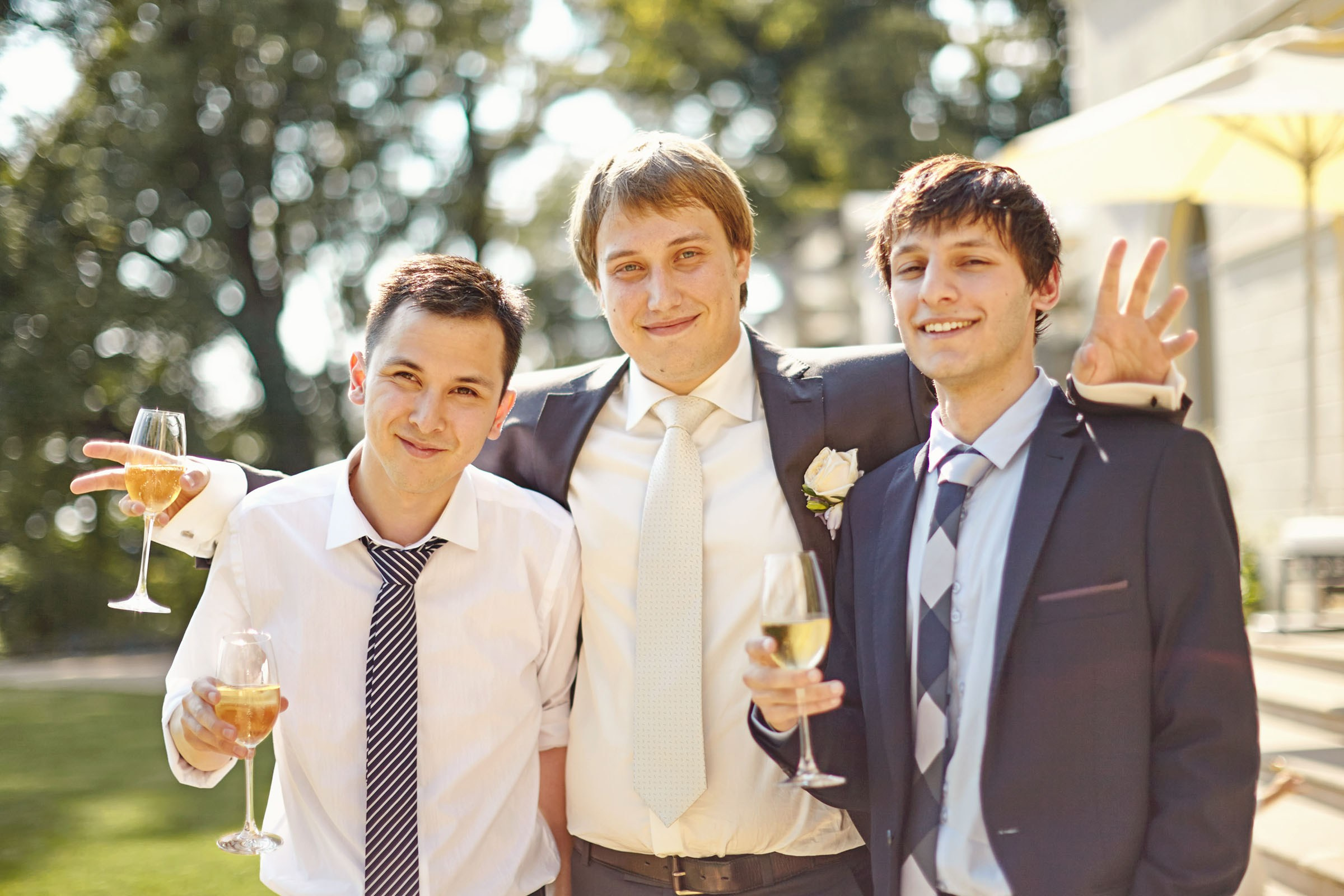 Groom with best mates toasting with champagne at chateau wedding.