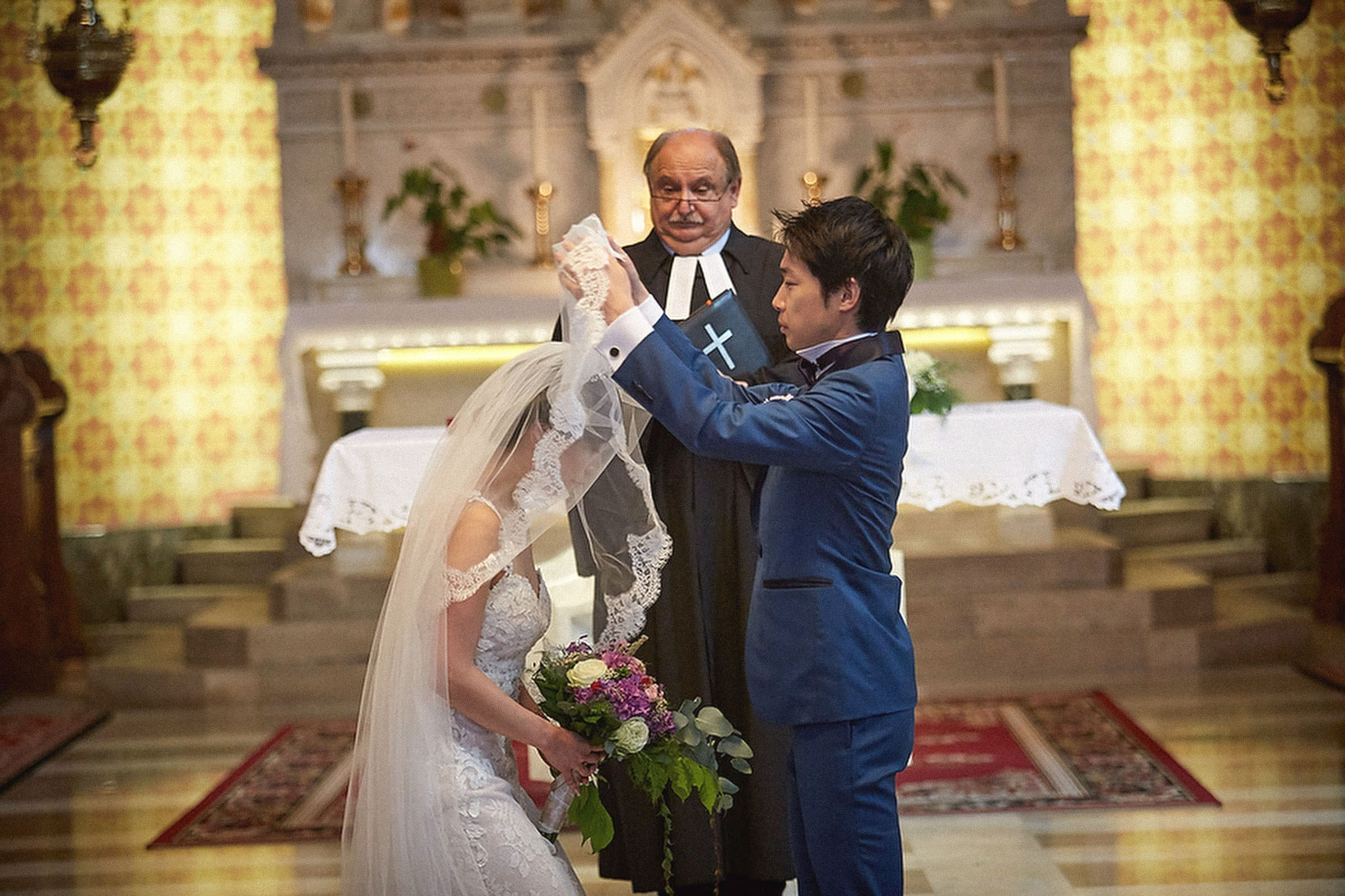 Young Japanese groom unveils his bride at St. Martin's Parish Church, Bled, Slovenia.