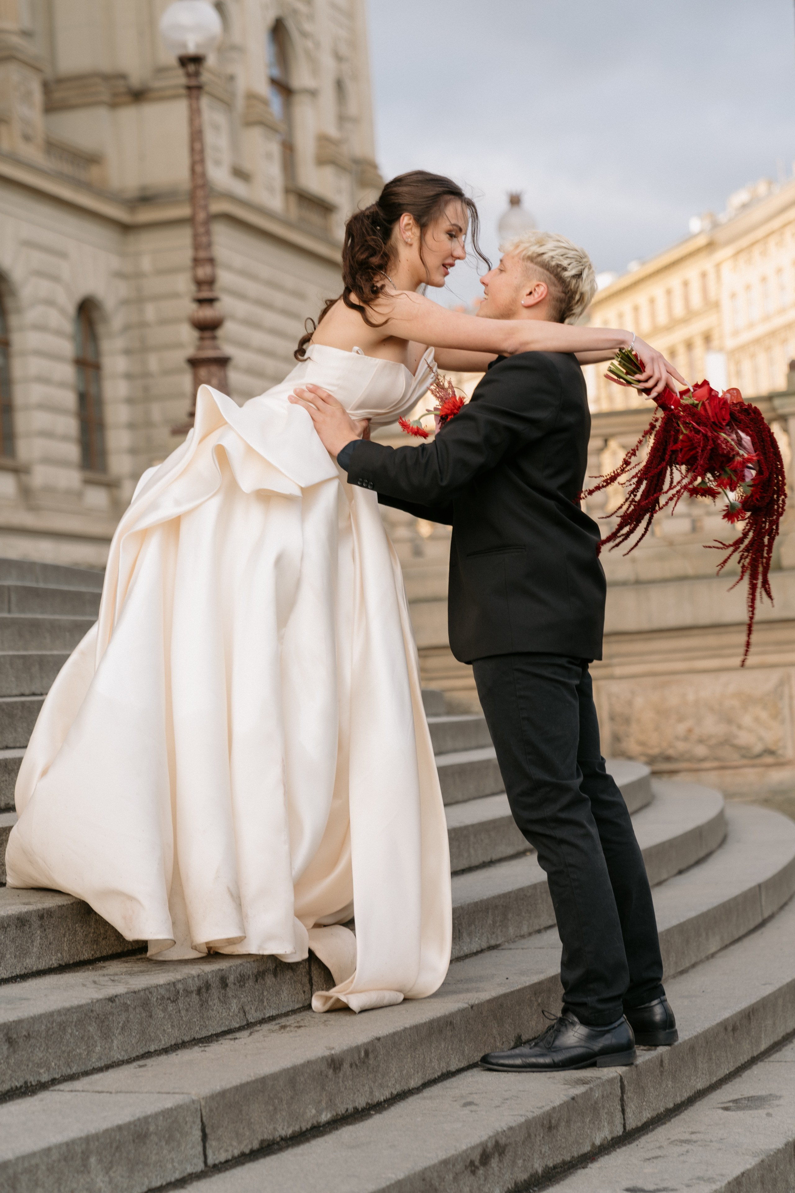 Intimní svatba ve dvou v Praze před Národním muzeem, spontánní svatební portrét zachycující radost, pohyb a blízkost novomanželů.