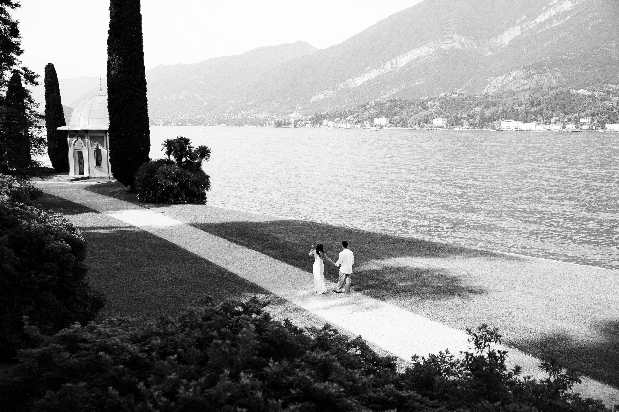 Black and white panoramic view of a couple walking along the Villa Melzi waterfront