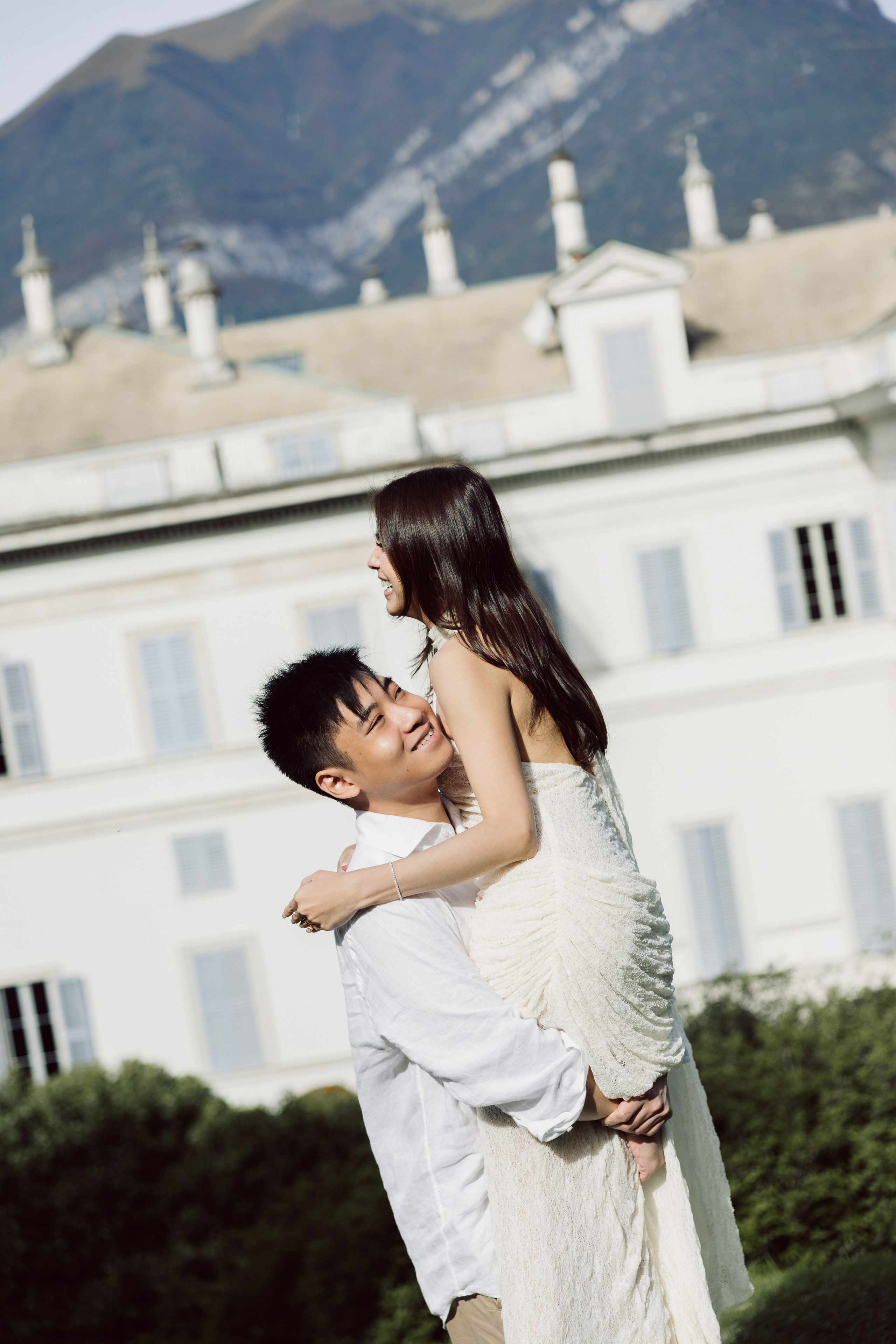 Man lifting his partner into his arms in front of a historic villa in Bellagio.