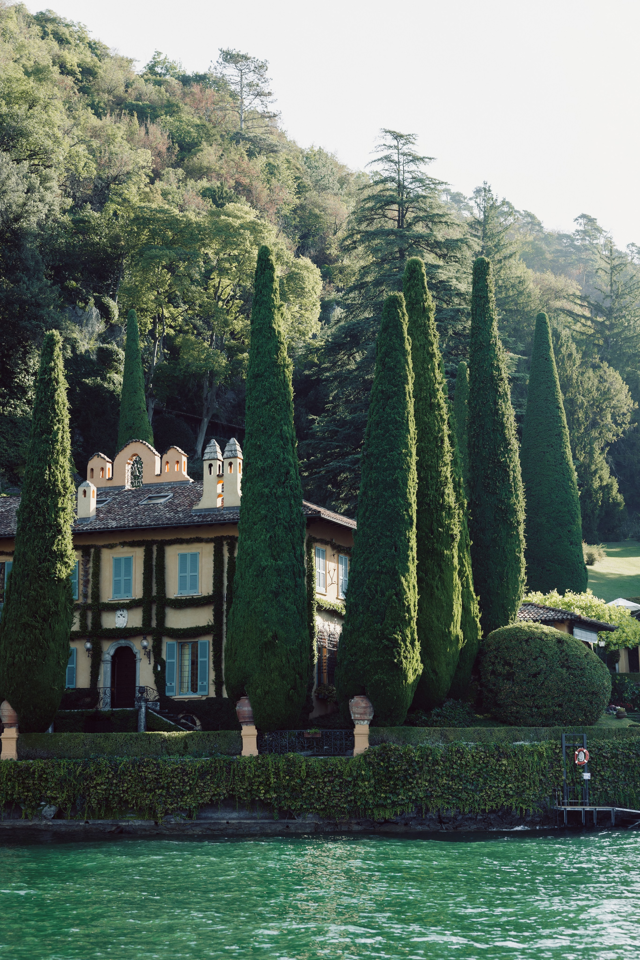 Historic lakeside villa surrounded by cypress trees on Lake Como in Bellagio, Italy