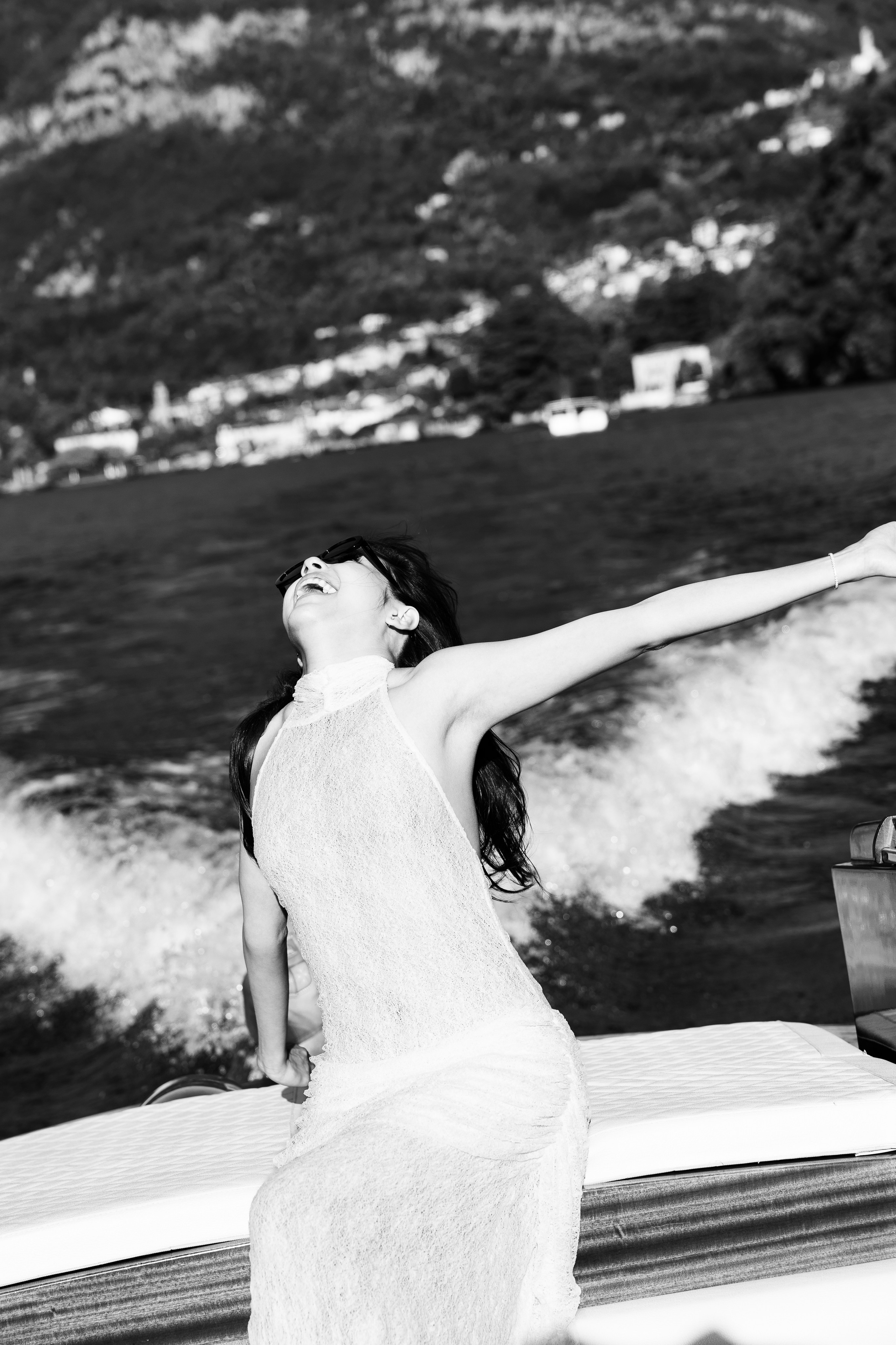 Black and white portrait of a woman enjoying the breeze on a private Lake Como boat