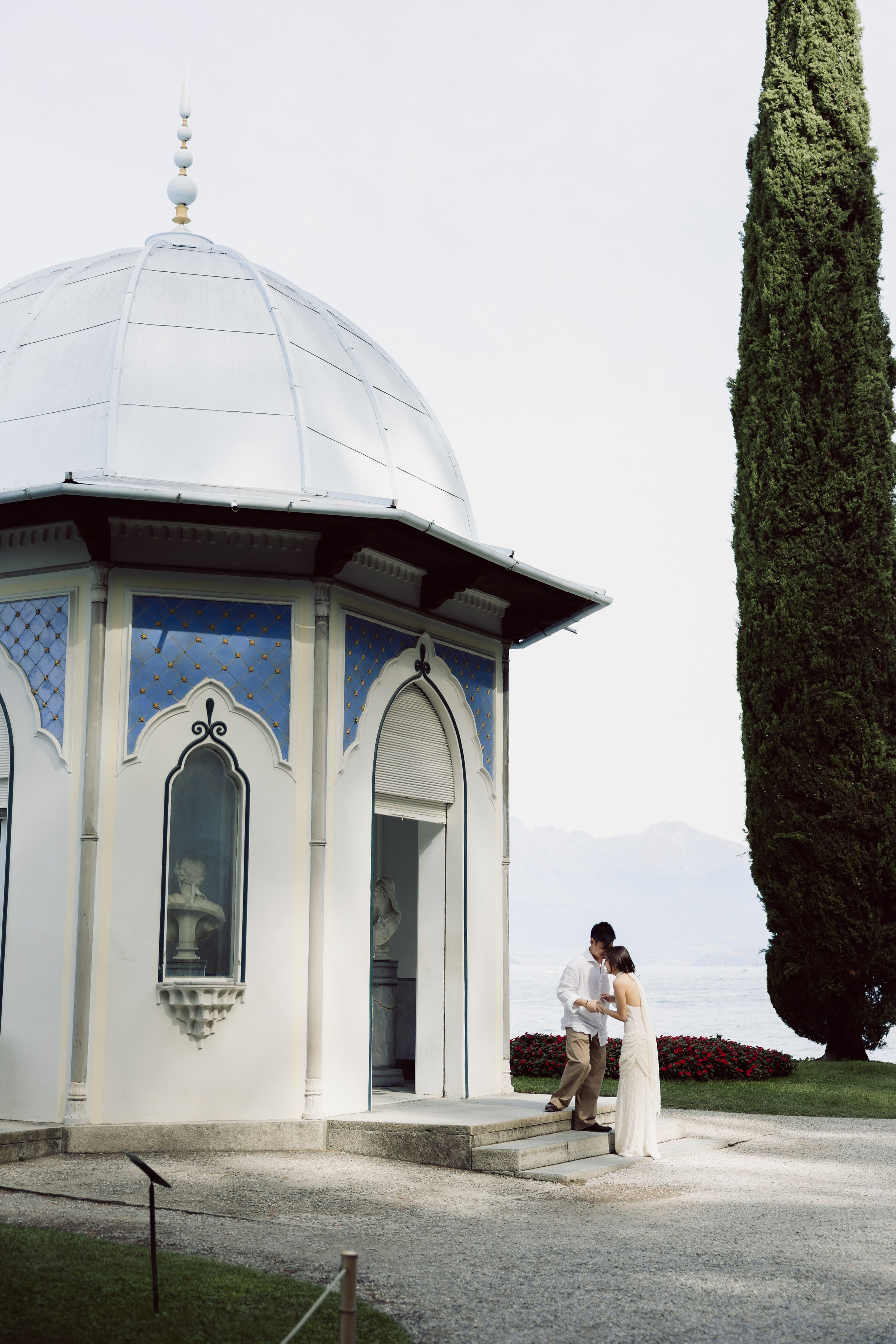 Historic lakeside pavilion framed by tall cypress trees at Villa Melzi Gardens