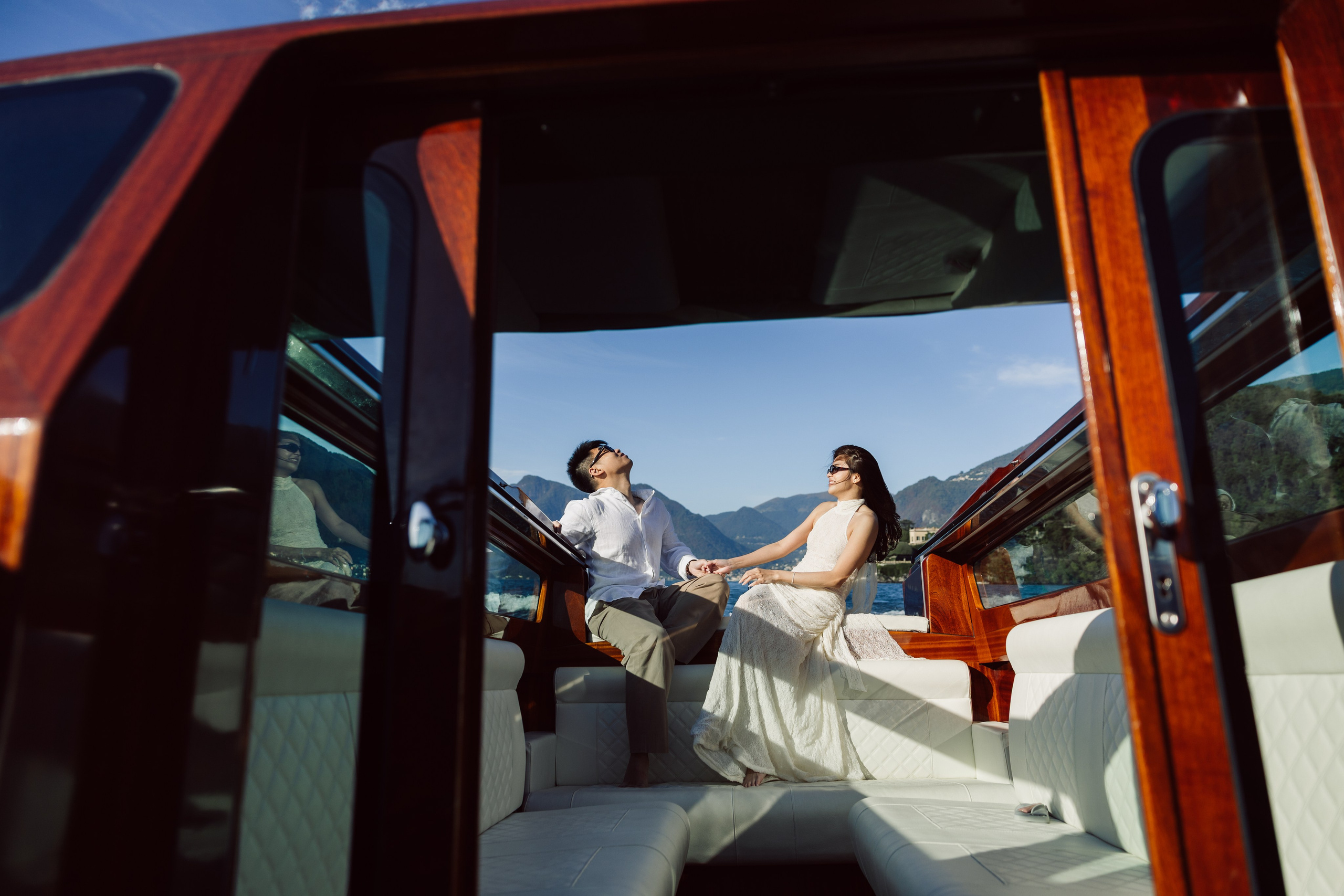 Couple enjoying a private wooden boat ride across Lake Como