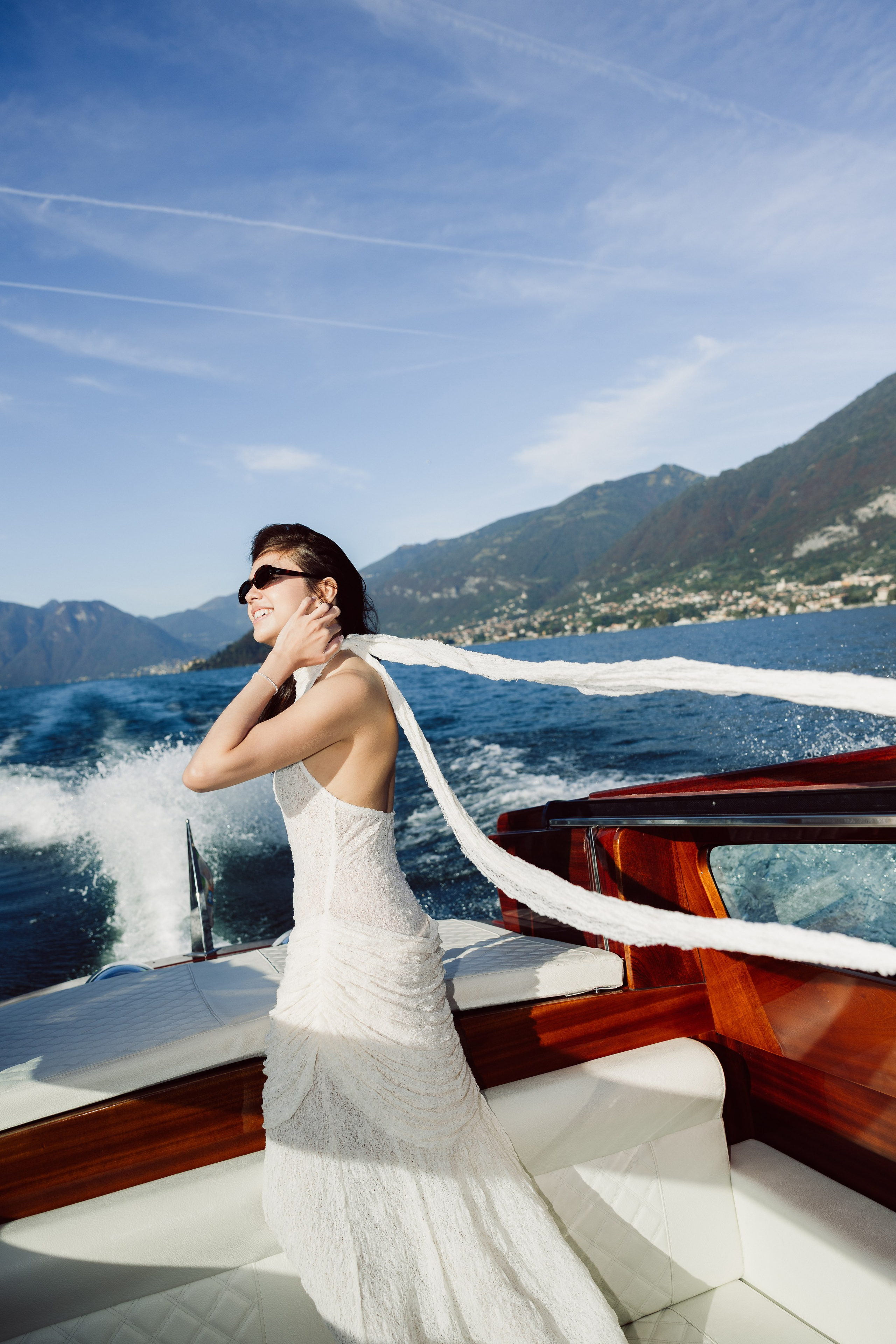 Woman enjoying the sunshine on a private boat during a Lake Como engagement session