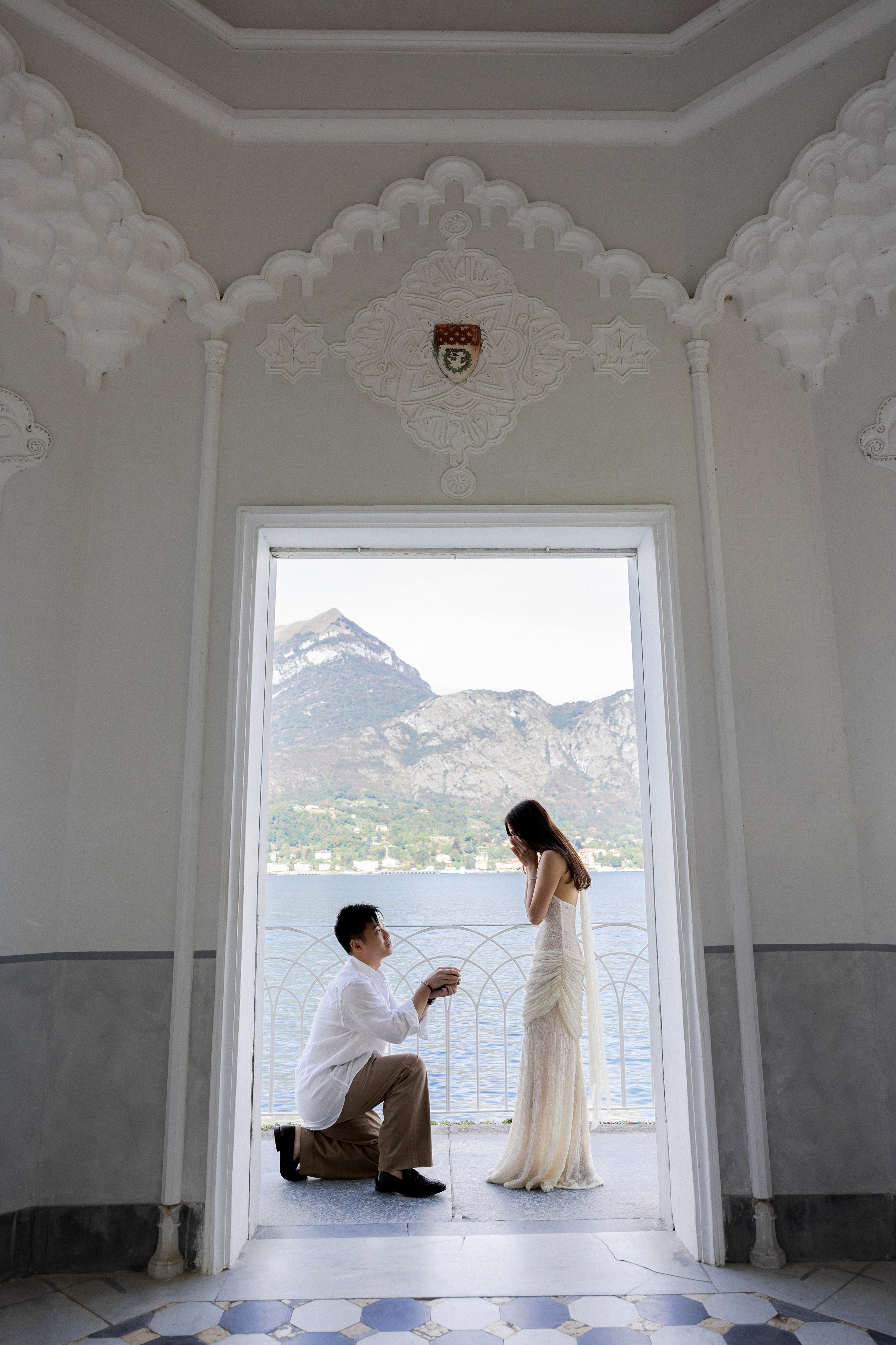 Man proposing on one knee inside a lakeside pavilion at Villa Melzi, Bellagio