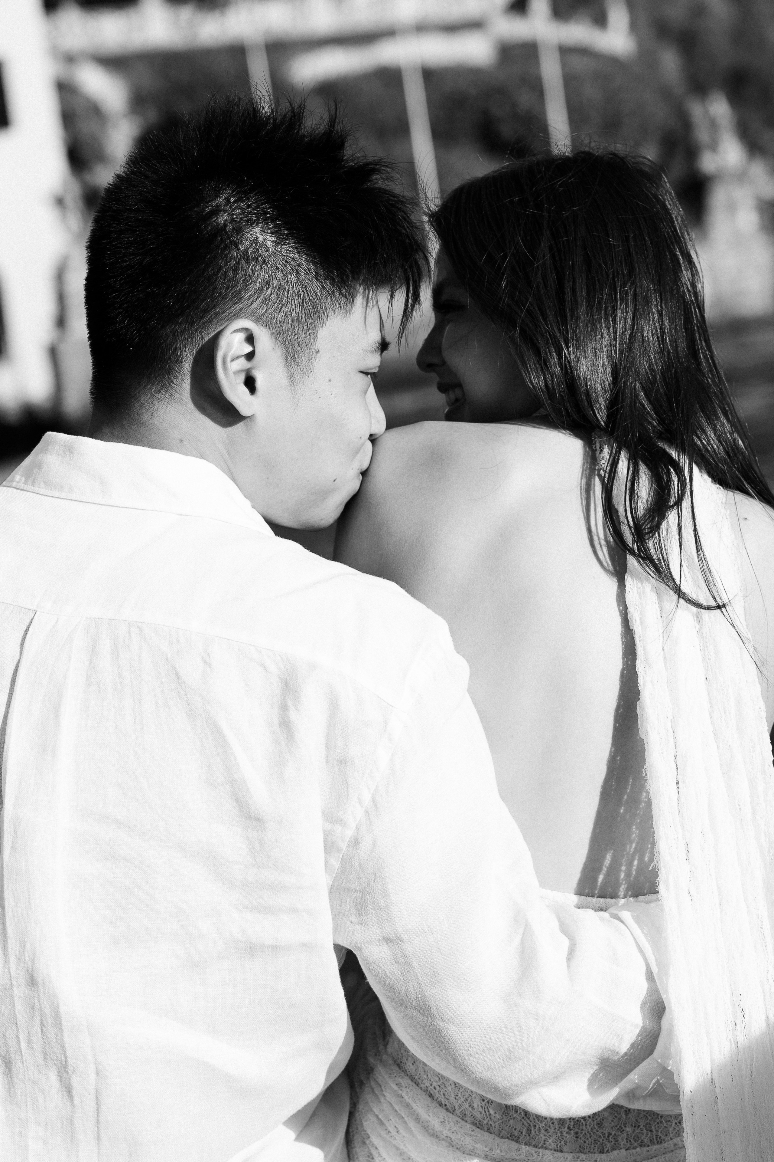 Black and white close-up of a man kissing his partner's shoulder during a couple photoshoot