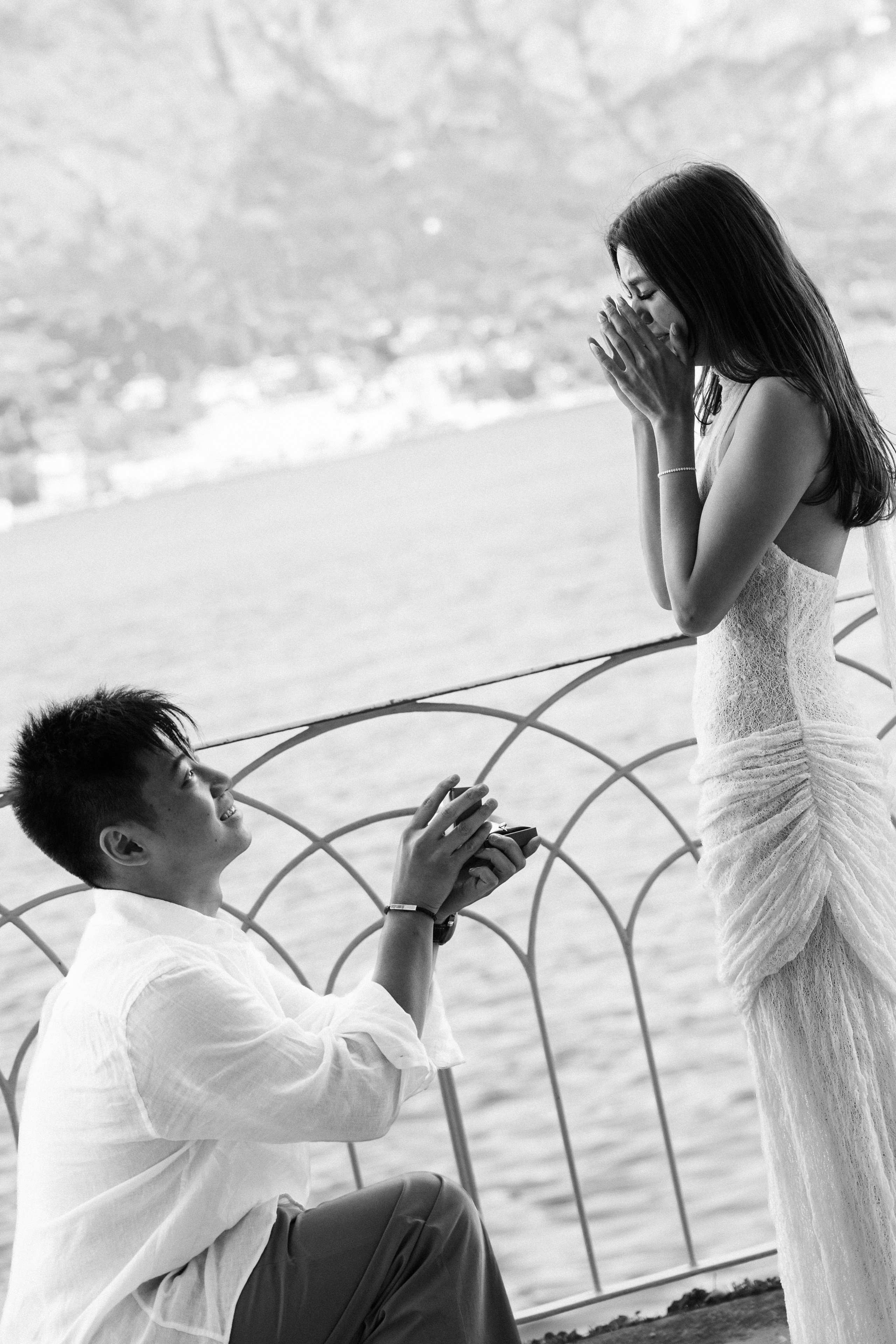 Black and white photo of a woman's emotional reaction to a surprise Lake Como proposal
