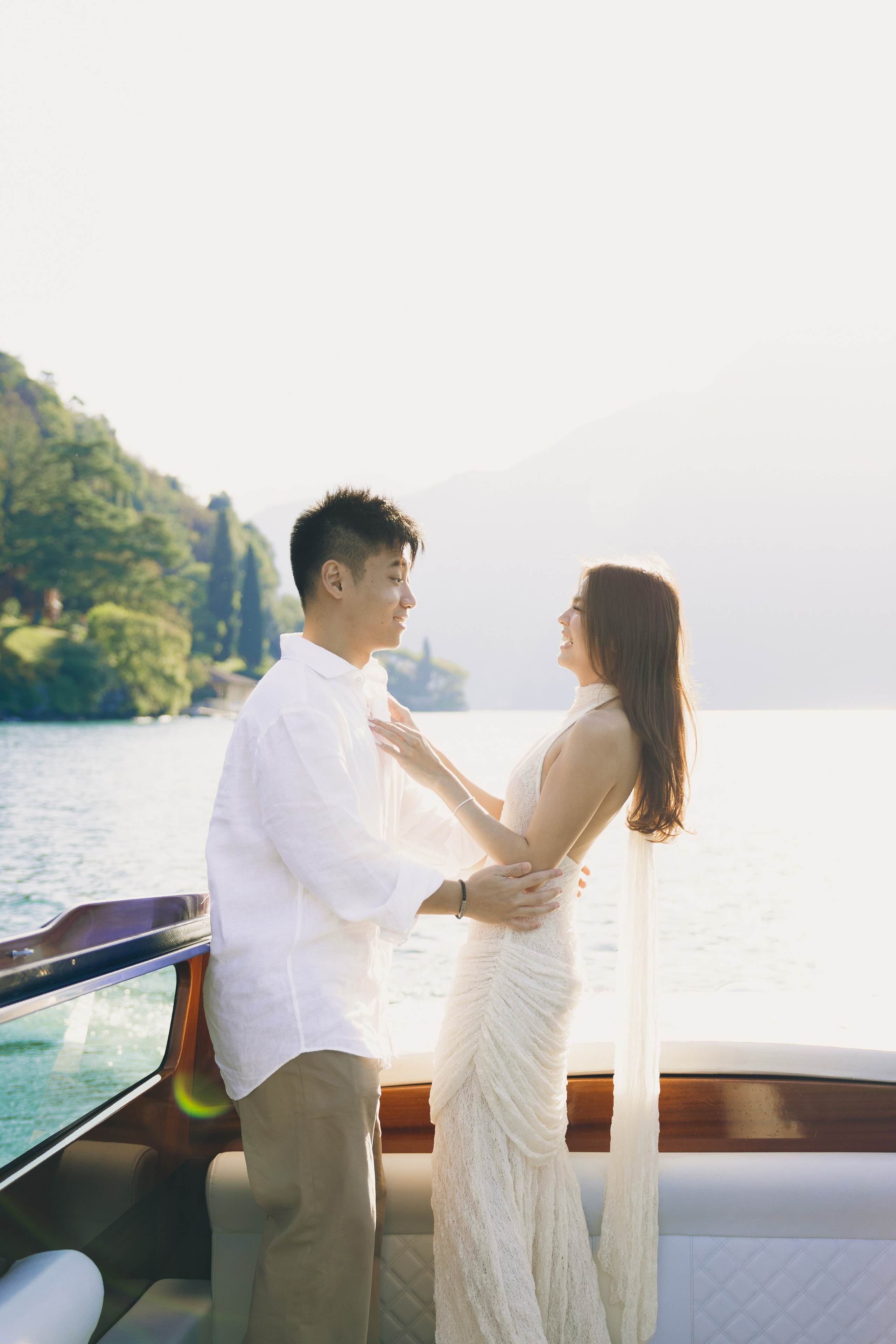 Couple holding hands on a private boat in the afternoon sunshine on Lake Como