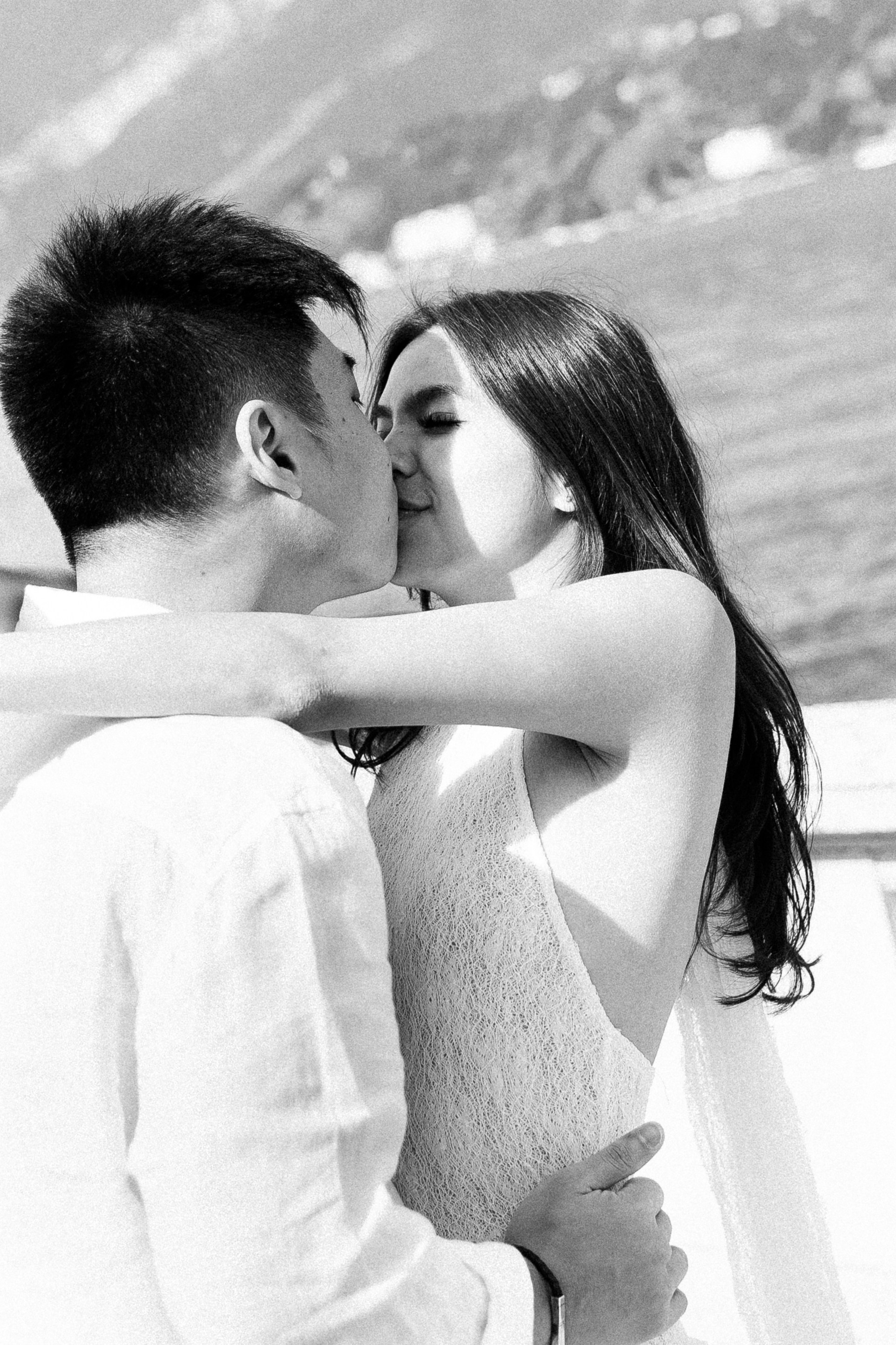 Romantic black and white engagement portrait of a couple kissing