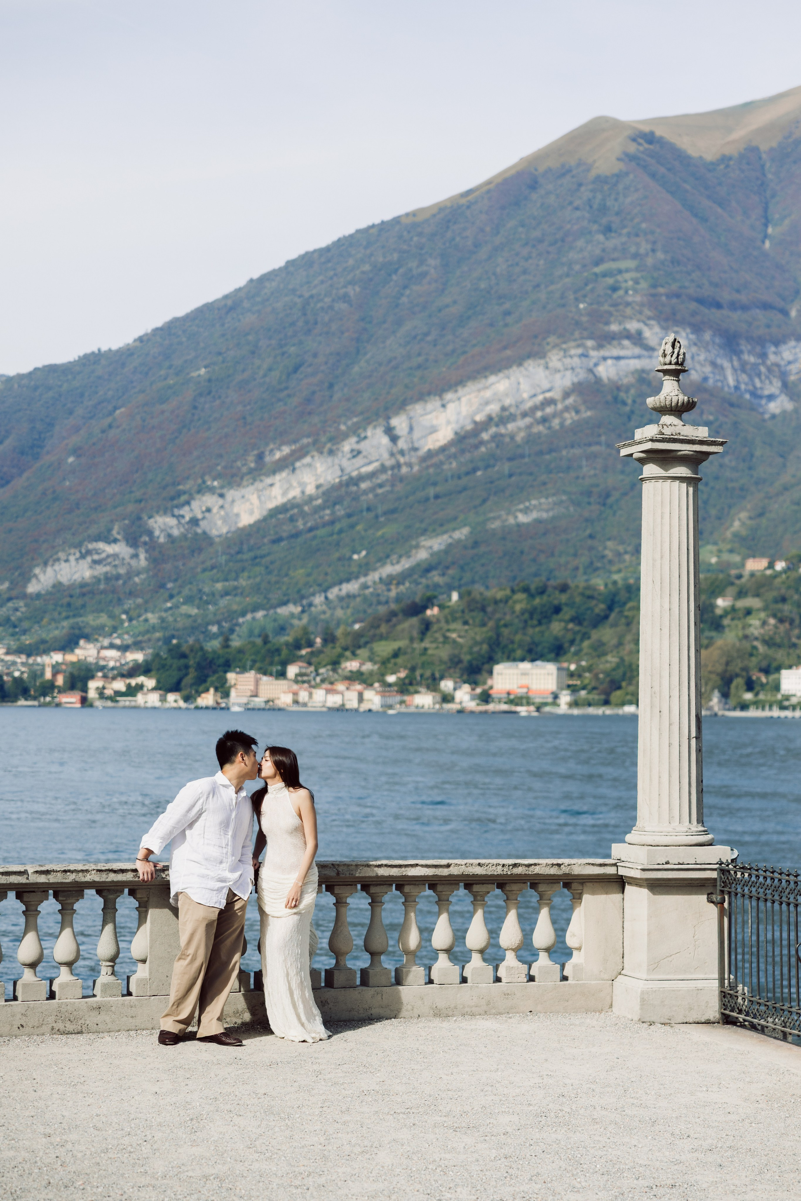Couple kissing beside the stone balustrade at Villa Melzi Gardens in Bellagio