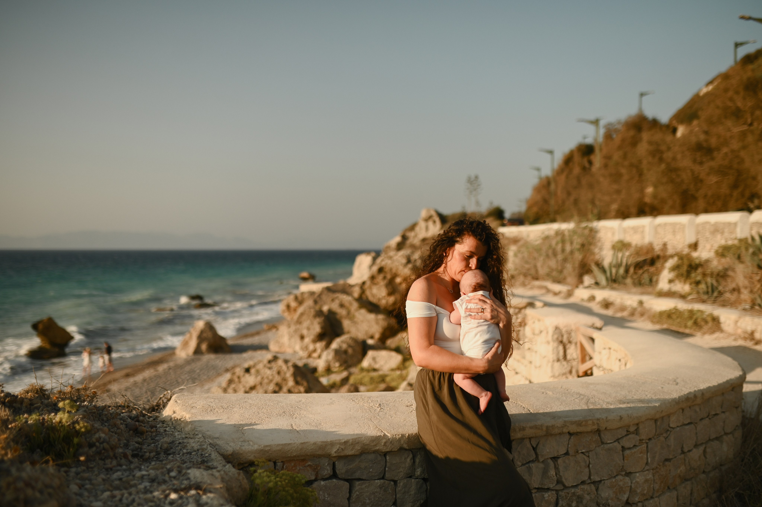 Happy family walking along a Rhodes beach at sunset. Photographer in Rhodes Island
