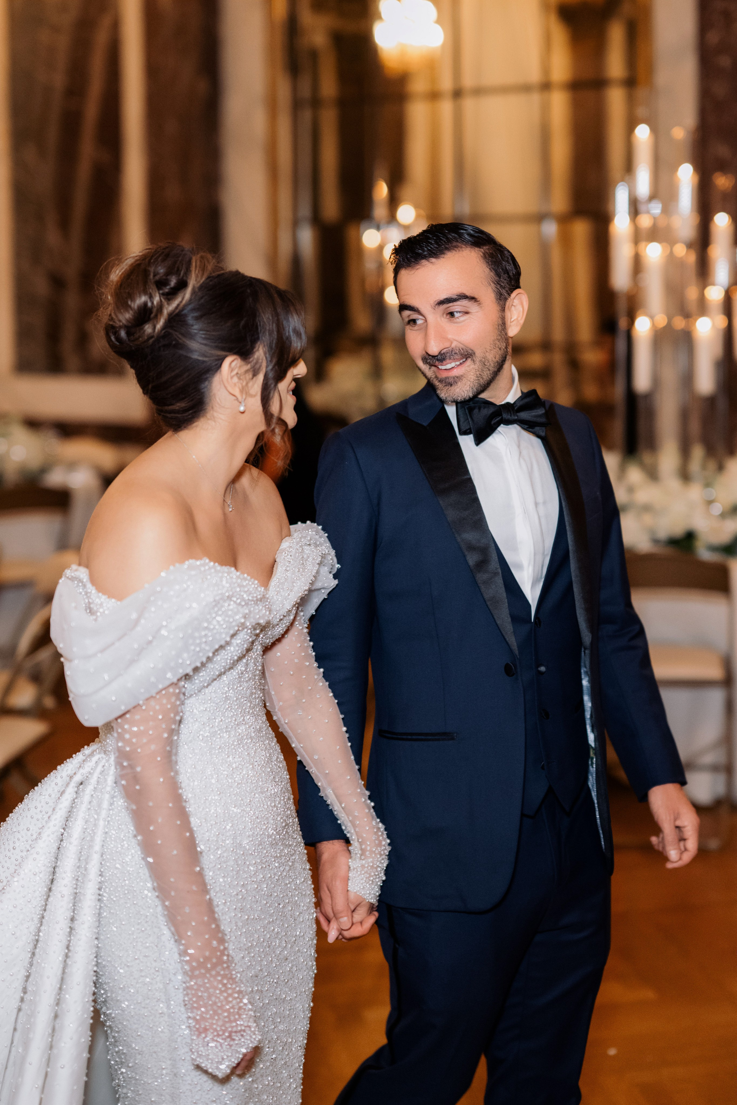 a bride and groom walking through the hall
