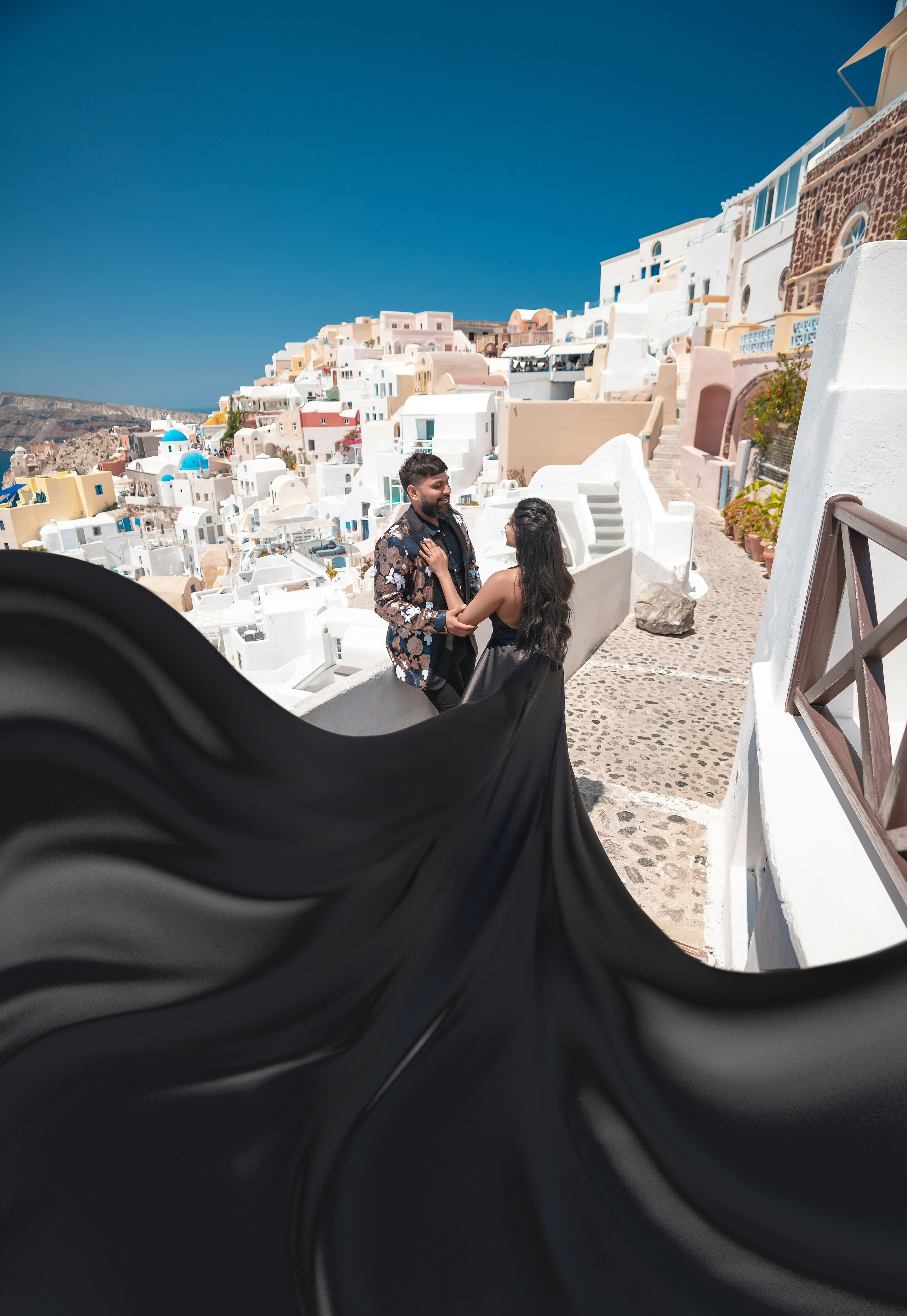 Séance photo avec une robe volante noire à Santorin: Élégance et magie intemporelles. Photographe vidéaste à Santorin|Séances photos de Robe volante Santorin|