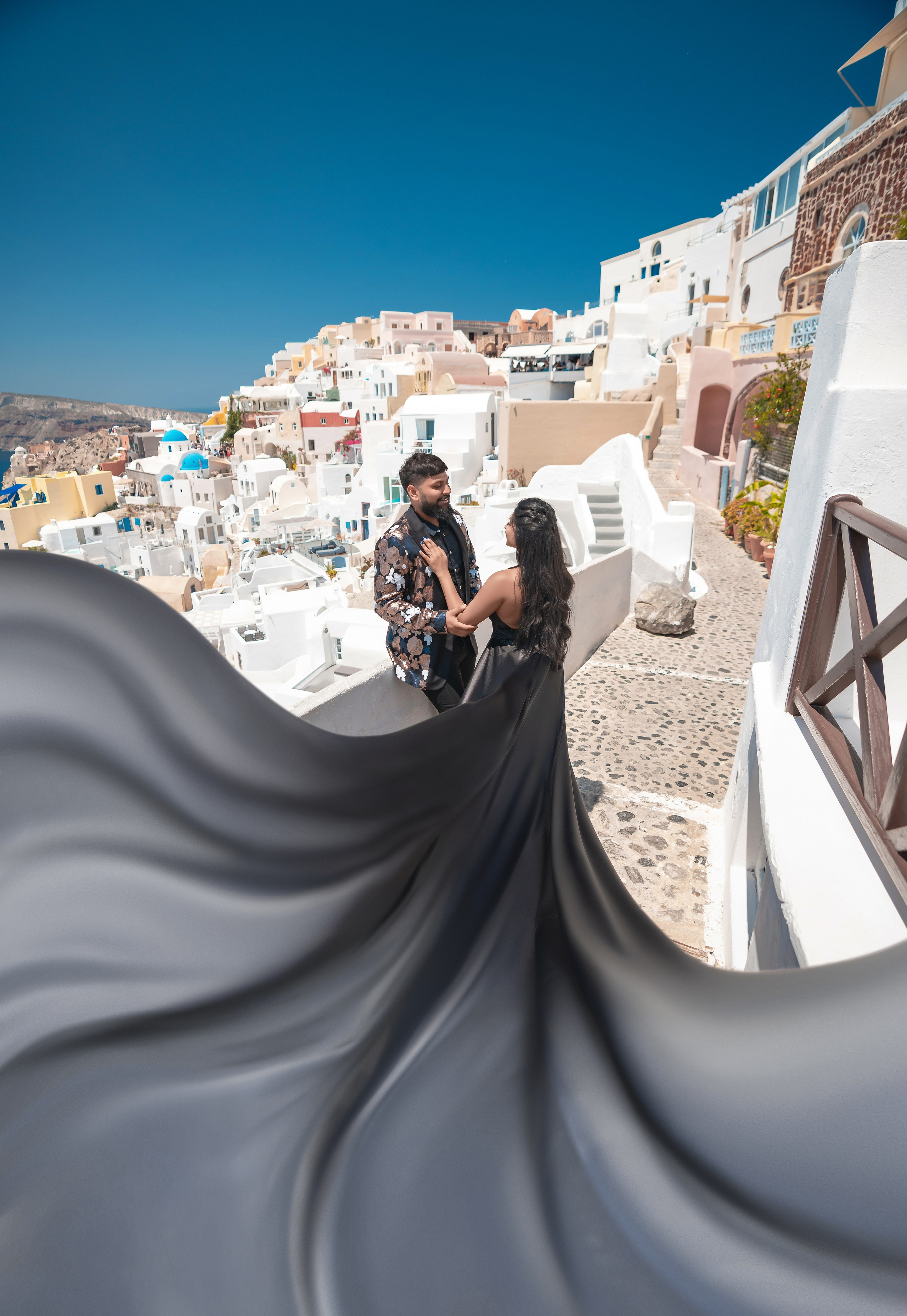 Séance photo avec une robe volante noire à Santorin: Élégance et magie intemporelles. Photographe vidéaste à Santorin|Séances photos de Robe volante Santorin|