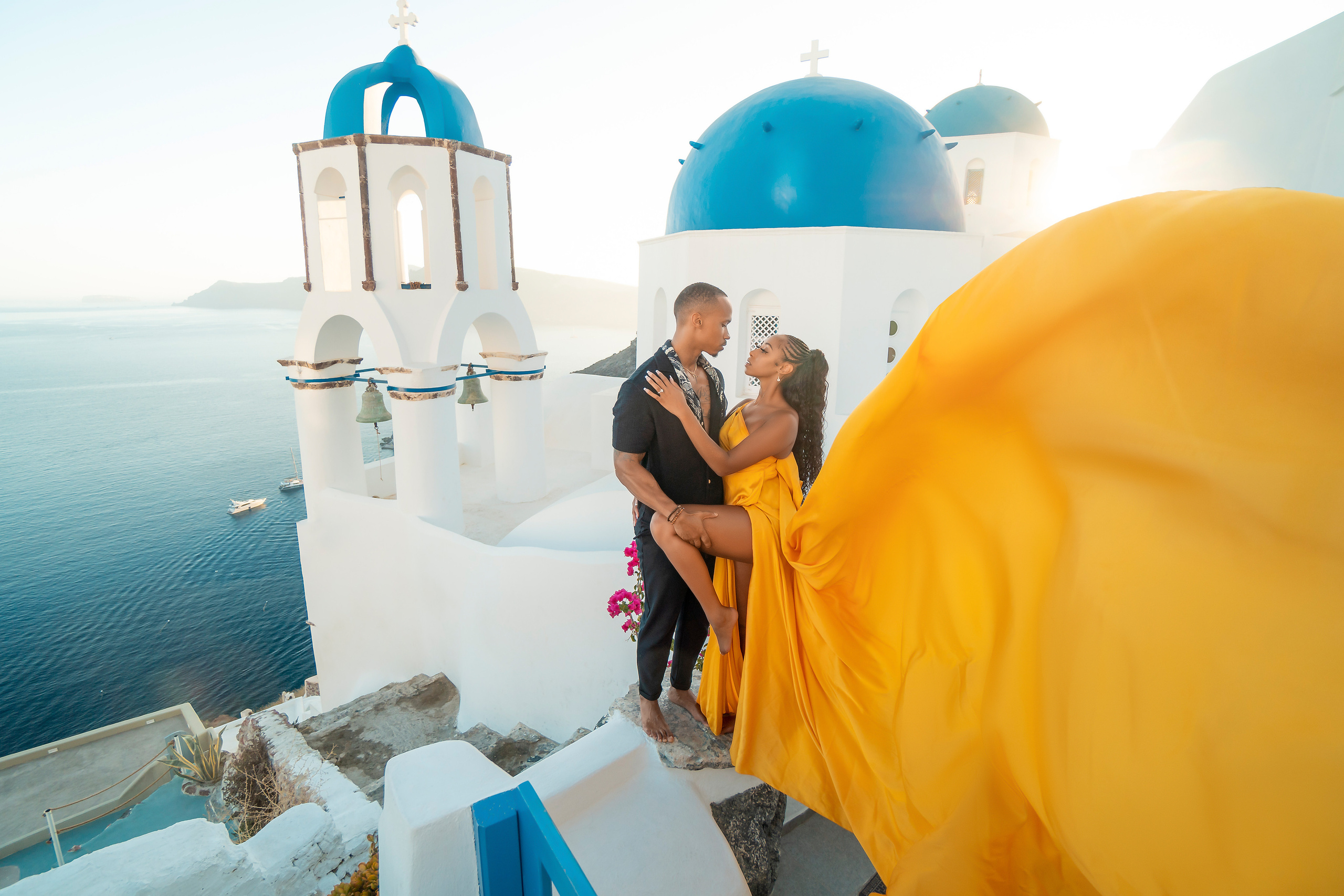 Amour et Lumière: Séance Photo d’un Couple au Coucher du Soleil à Oia, Santorin. Photographe vidéaste à Santorin|Séances photos de Robe volante Santorin|
