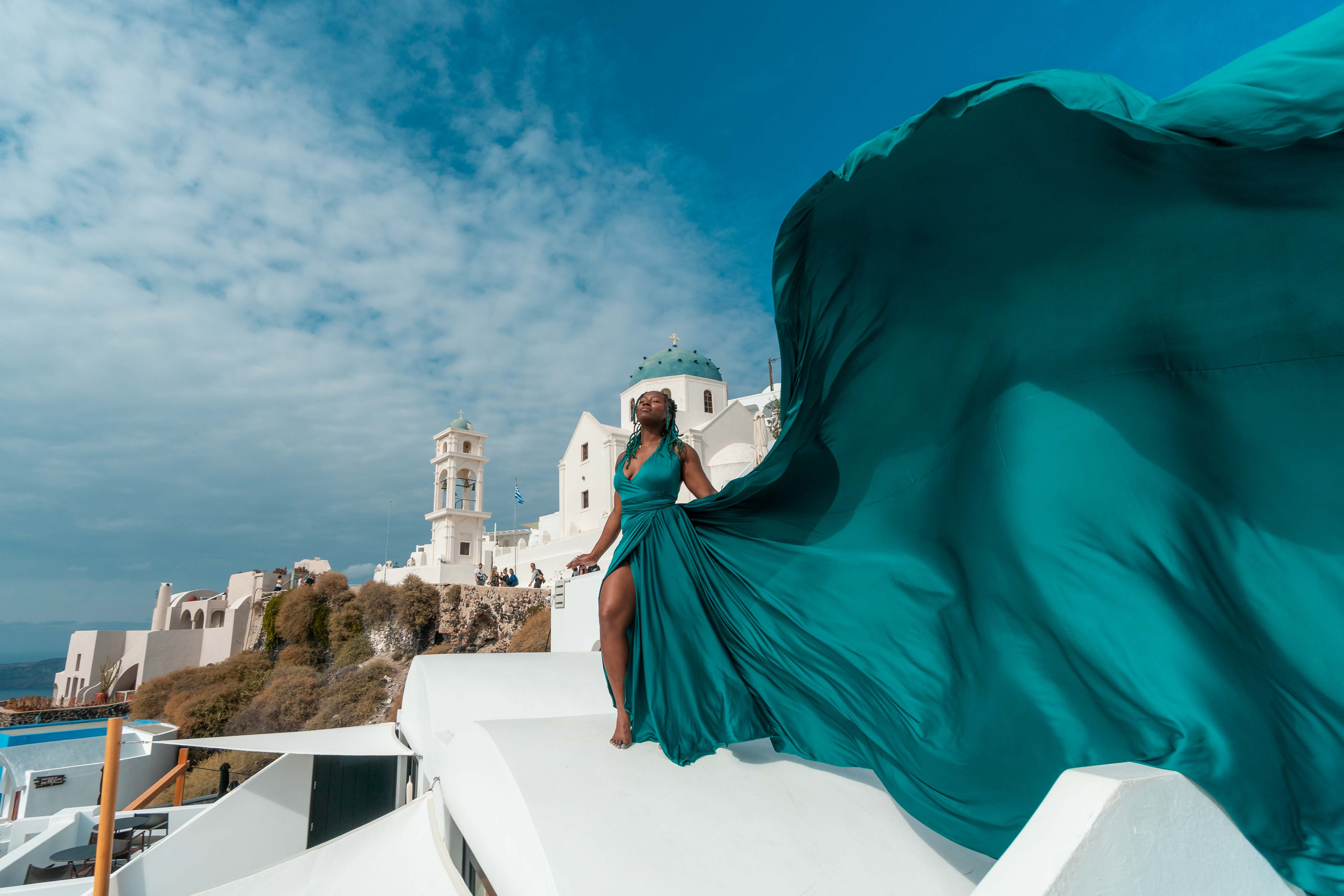 Rent the stunning dark green flying dress by Sokolove for captivating Santorini photos. With its dramatic bare-back design, this dress fits sizes XS-L and creates unforgettable visuals