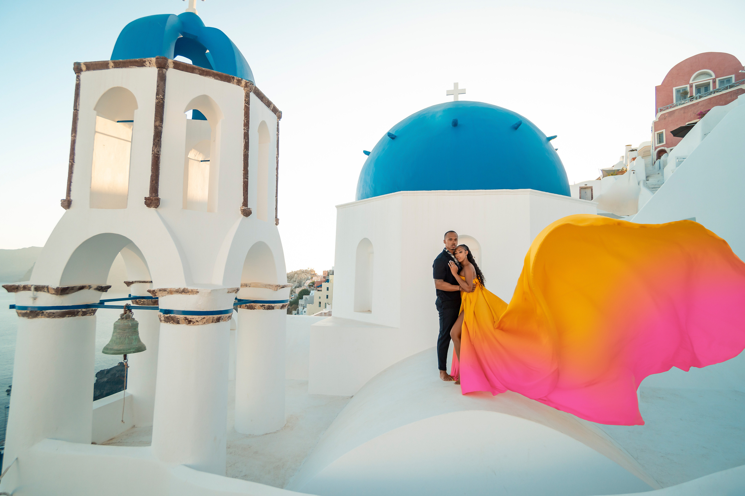Amour et Lumière: Séance Photo d’un Couple au Coucher du Soleil à Oia, Santorin. Photographe vidéaste à Santorin|Séances photos de Robe volante Santorin|