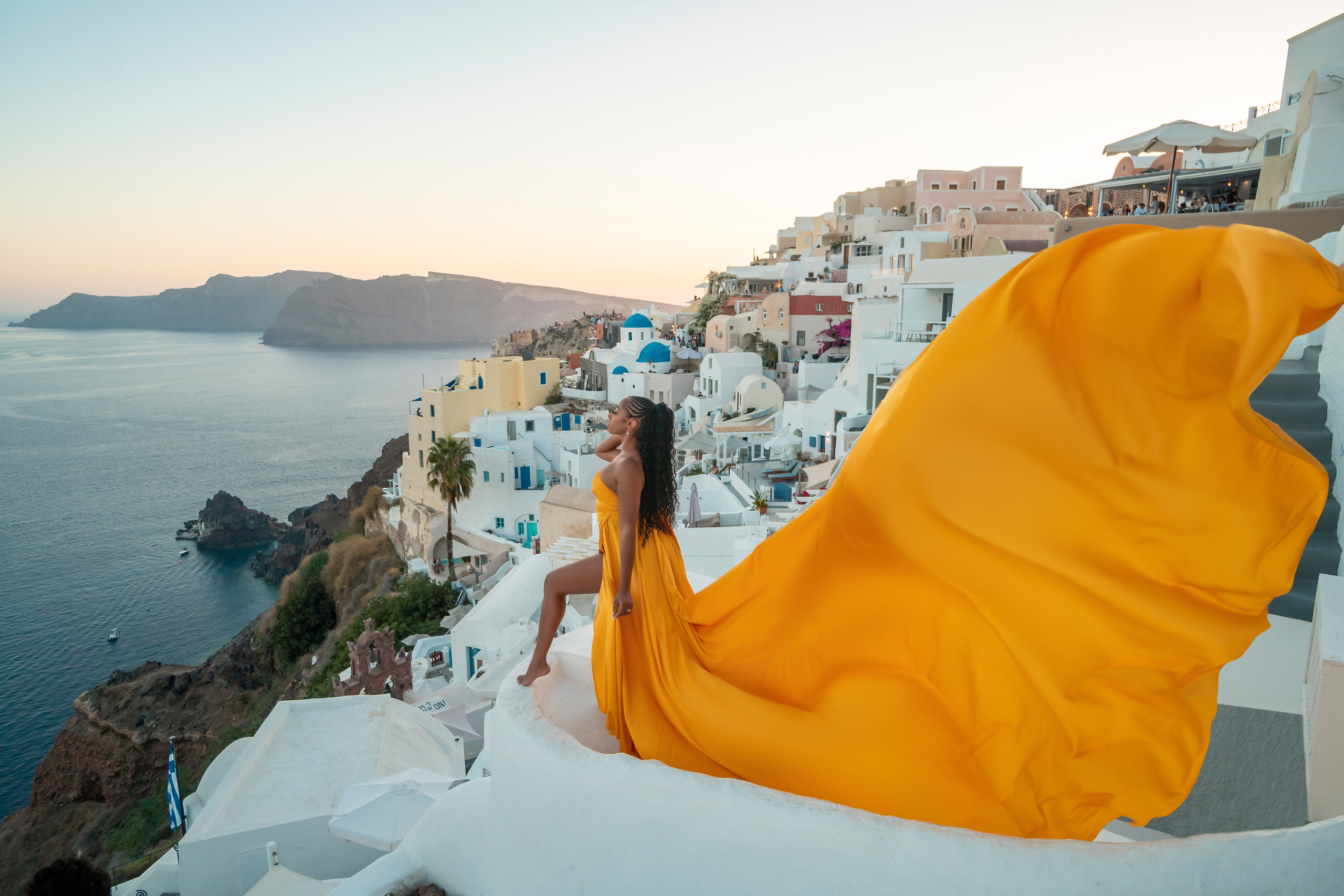 Amour et Lumière: Séance Photo d’un Couple au Coucher du Soleil à Oia, Santorin. Photographe vidéaste à Santorin|Séances photos de Robe volante Santorin|