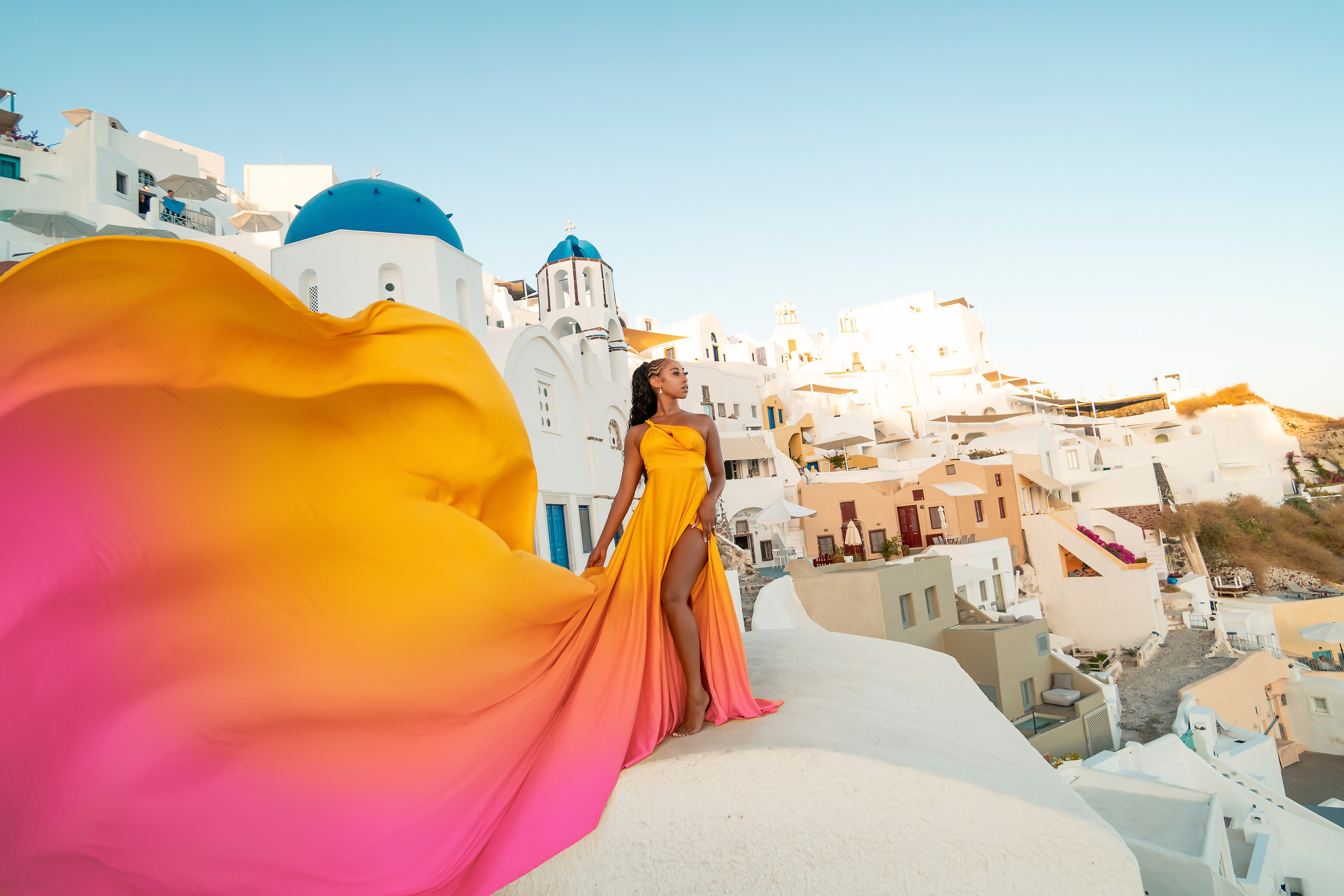 Amour et Lumière: Séance Photo d’un Couple au Coucher du Soleil à Oia, Santorin. Photographe vidéaste à Santorin|Séances photos de Robe volante Santorin|