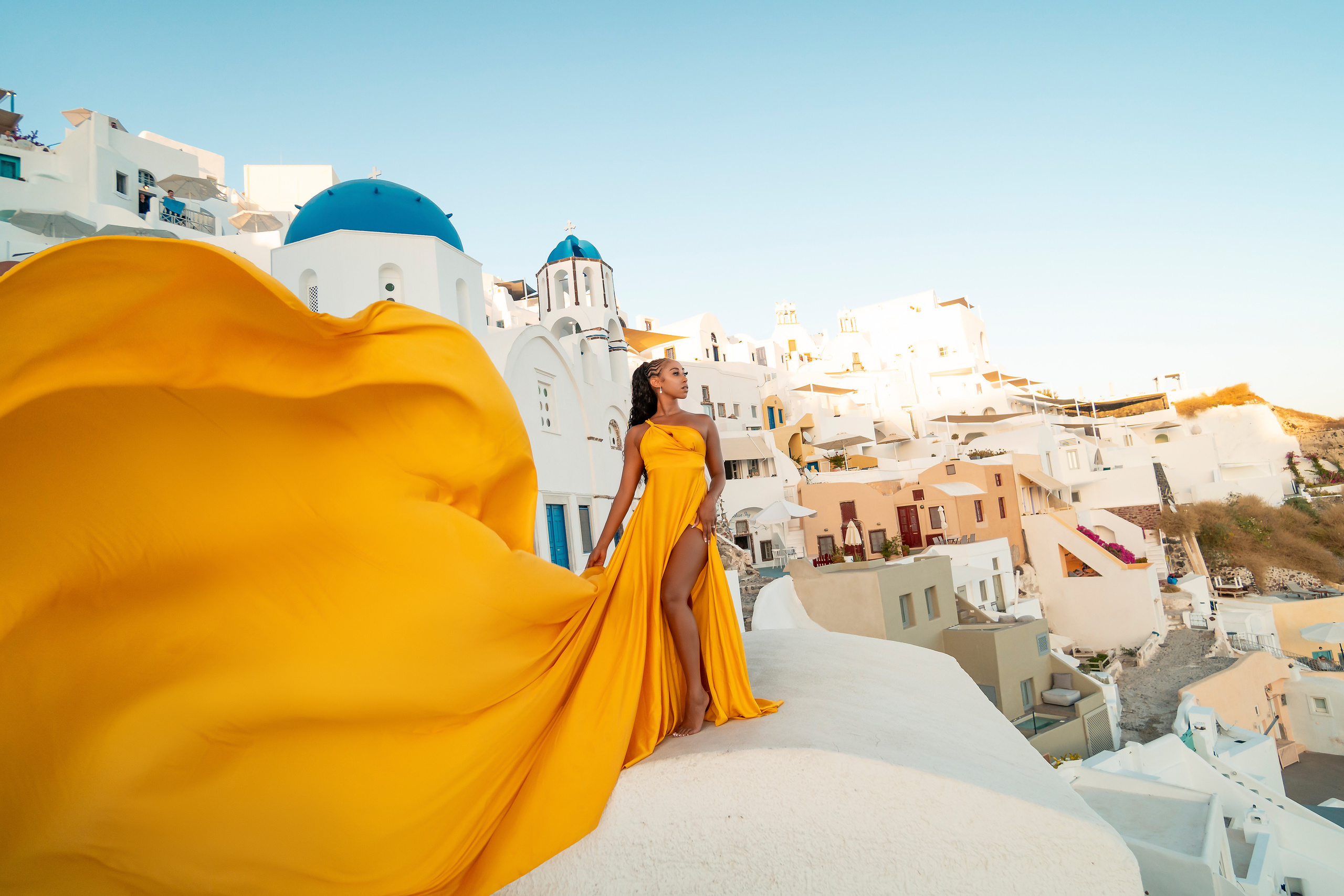 Amour et Lumière: Séance Photo d’un Couple au Coucher du Soleil à Oia, Santorin. Photographe vidéaste à Santorin|Séances photos de Robe volante Santorin|