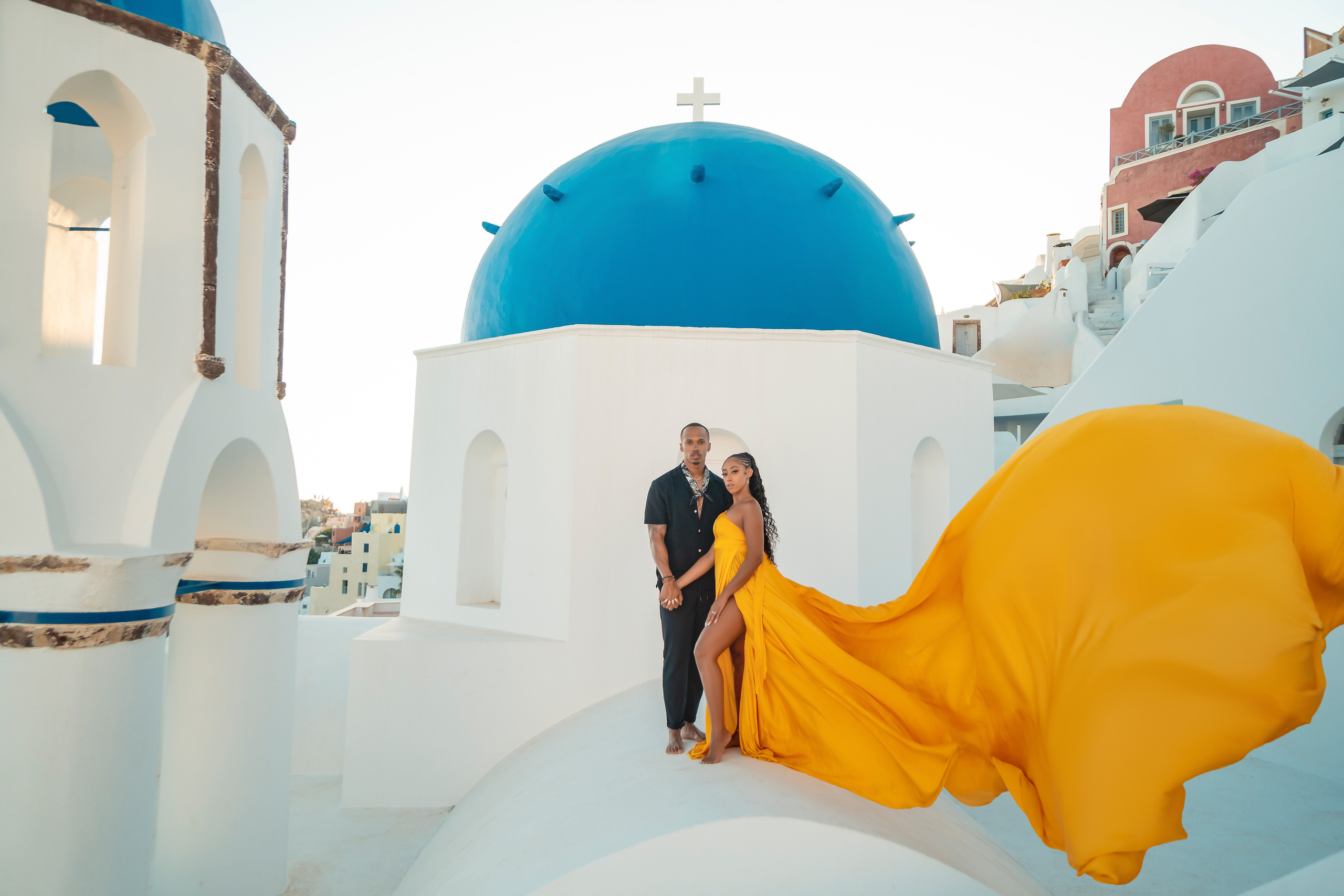 Amour et Lumière: Séance Photo d’un Couple au Coucher du Soleil à Oia, Santorin. Photographe vidéaste à Santorin|Séances photos de Robe volante Santorin|
