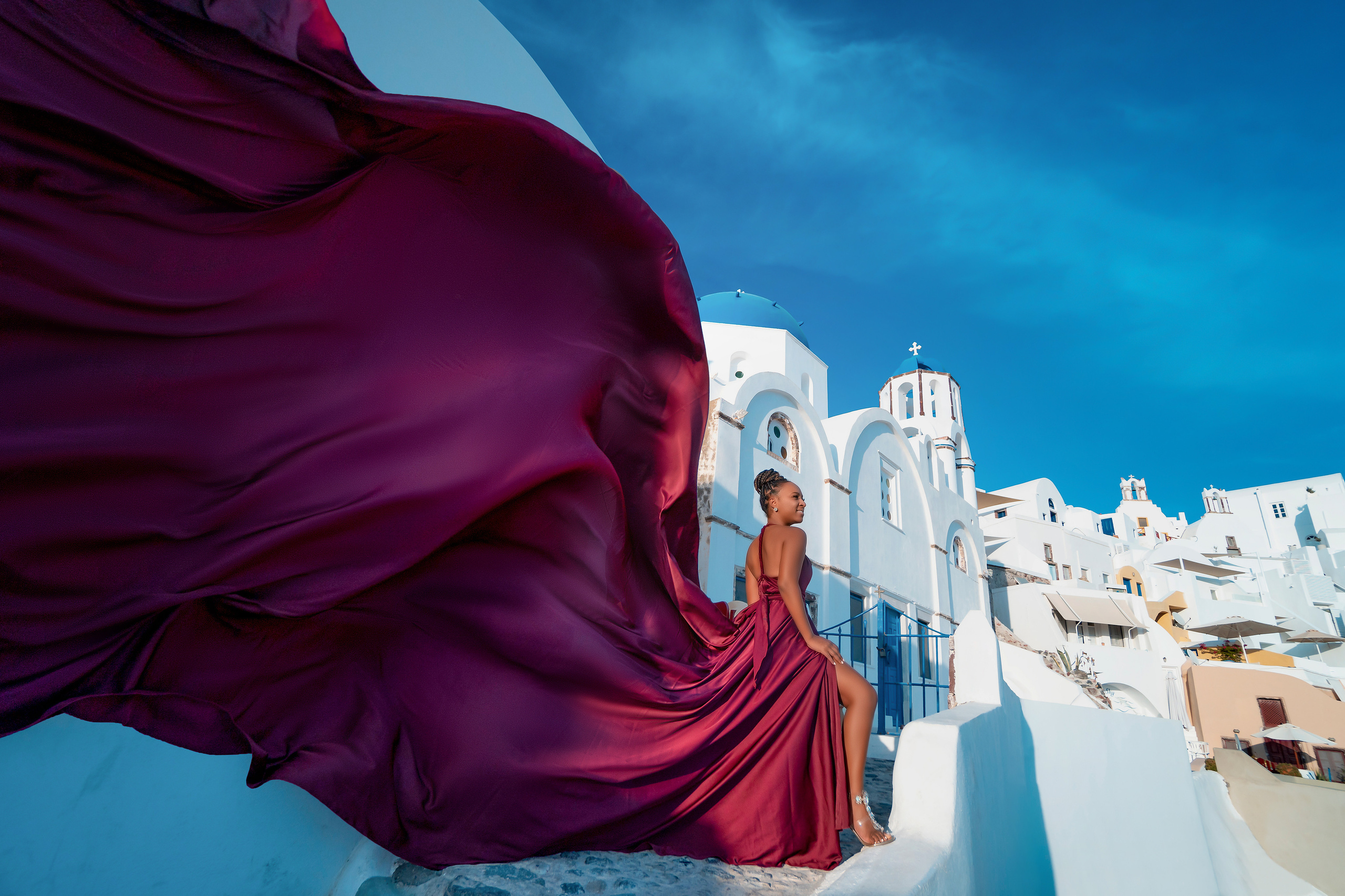 Photo session in Oia, Santorini at sunset, cherry flying dress. Photographer in Santorini SokoLOVE Alex| Flying Dress Santorini