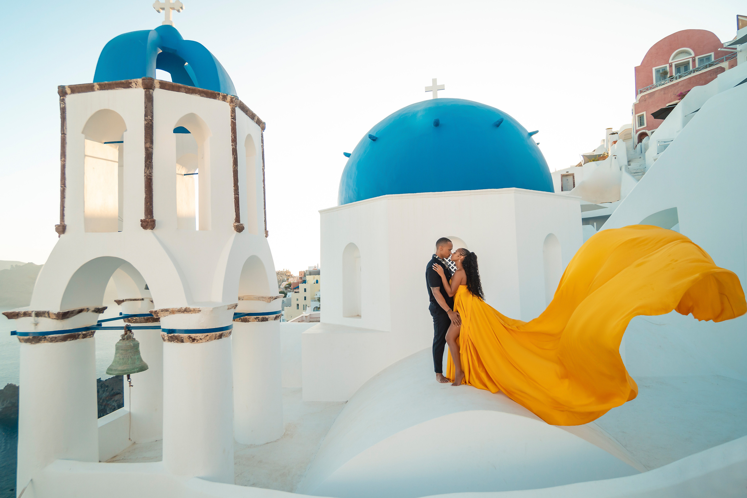 Amour et Lumière: Séance Photo d’un Couple au Coucher du Soleil à Oia, Santorin. Photographe vidéaste à Santorin|Séances photos de Robe volante Santorin|