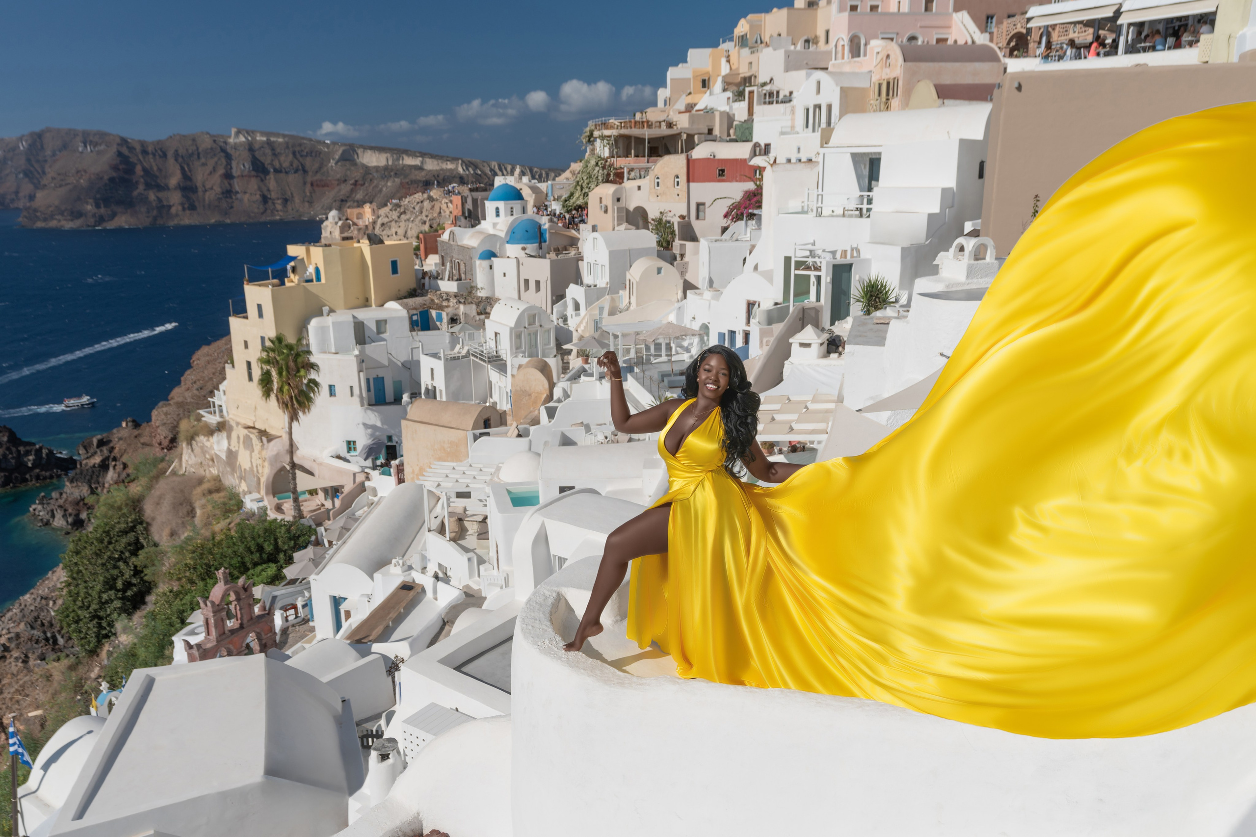 Élégance Dorée à Santorin: Séance Photo en Robe Volante Jaune – Moments Inoubliables. Photographe vidéaste à Santorin|Séances photos de Robe volante Santorin|