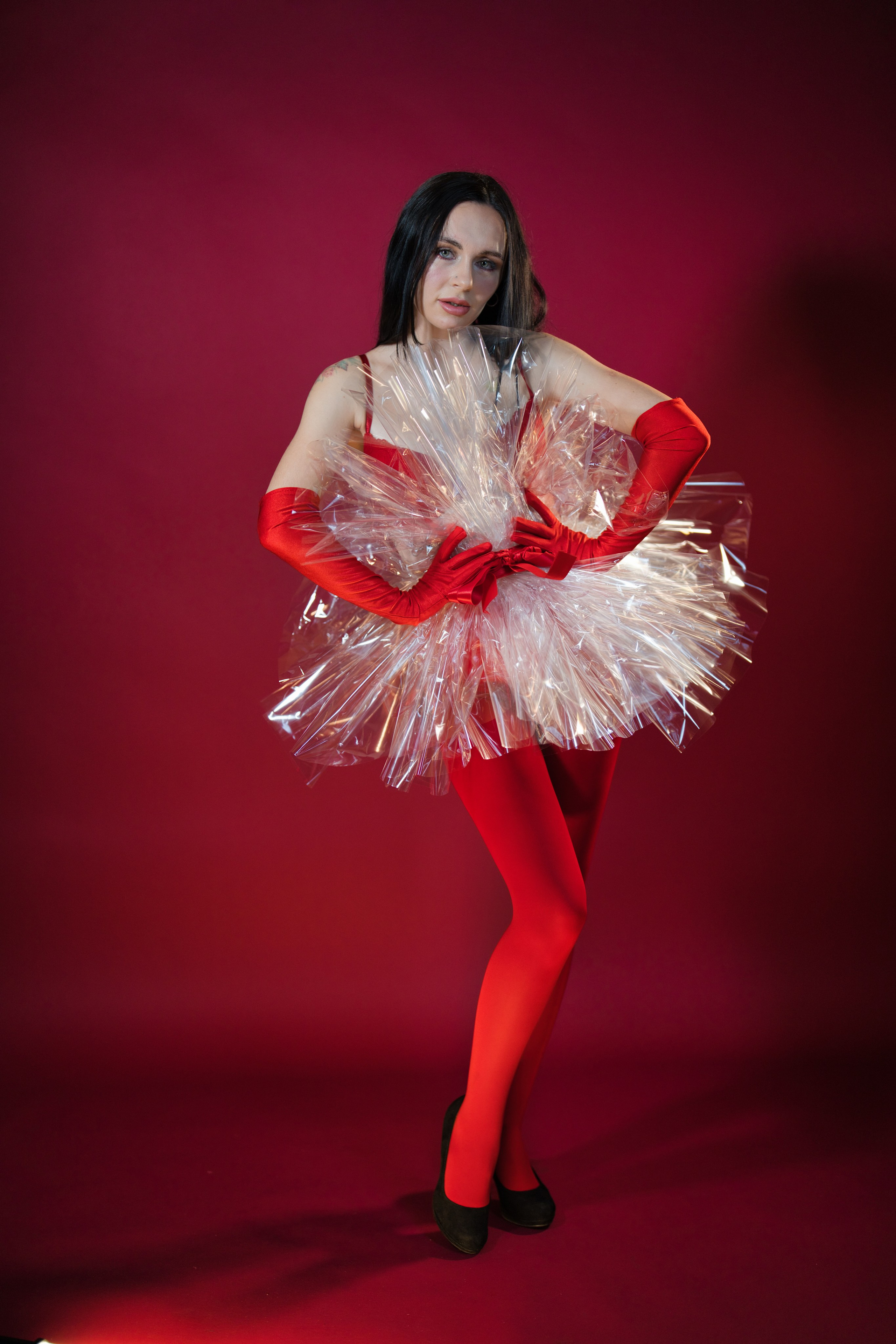 Frau vor rotem Hintergrund mit detaillierten weihnachtlichen Accessoires.