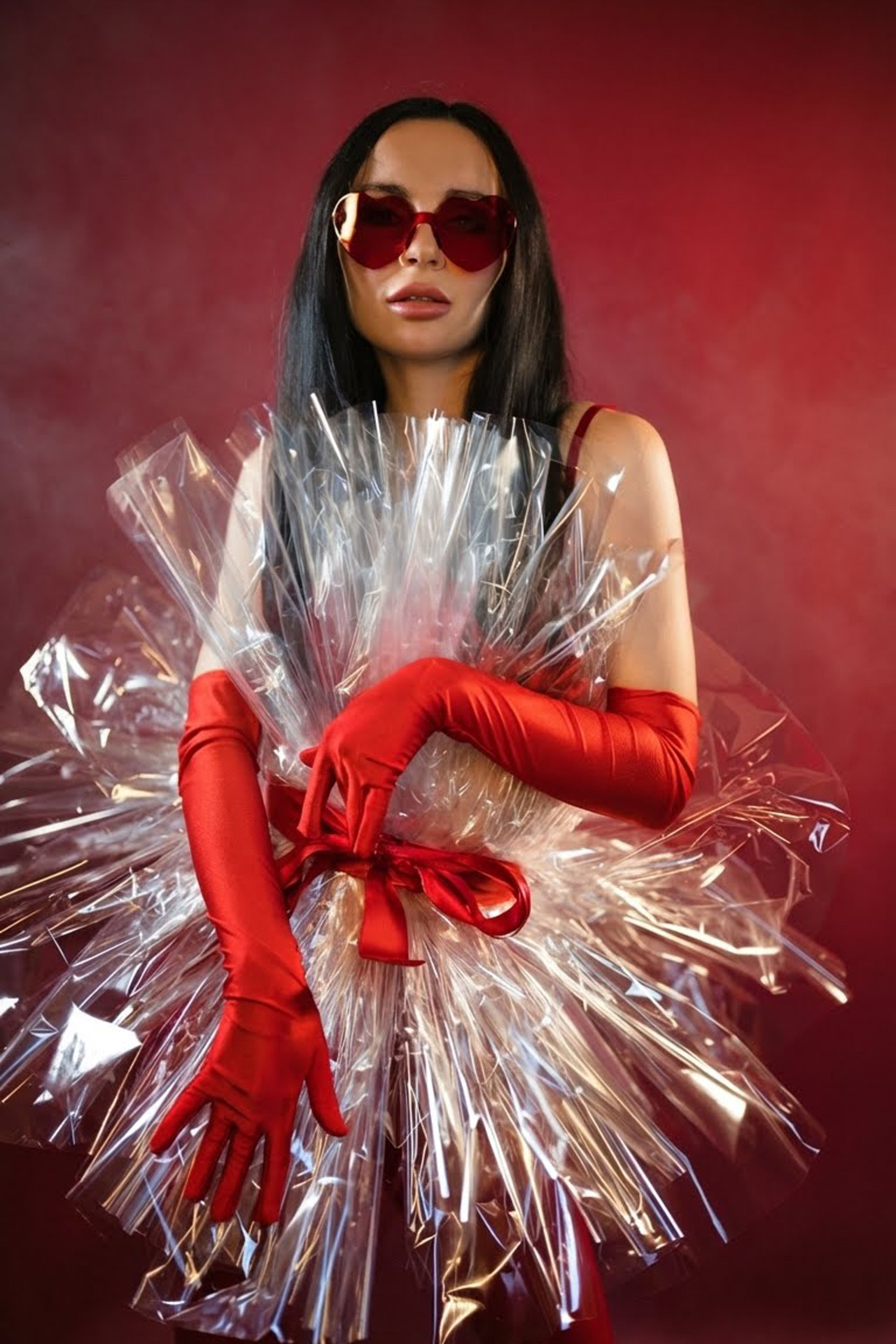 Porträt einer Frau im festlichen Kleid im Studio mit rotem Hintergrund.