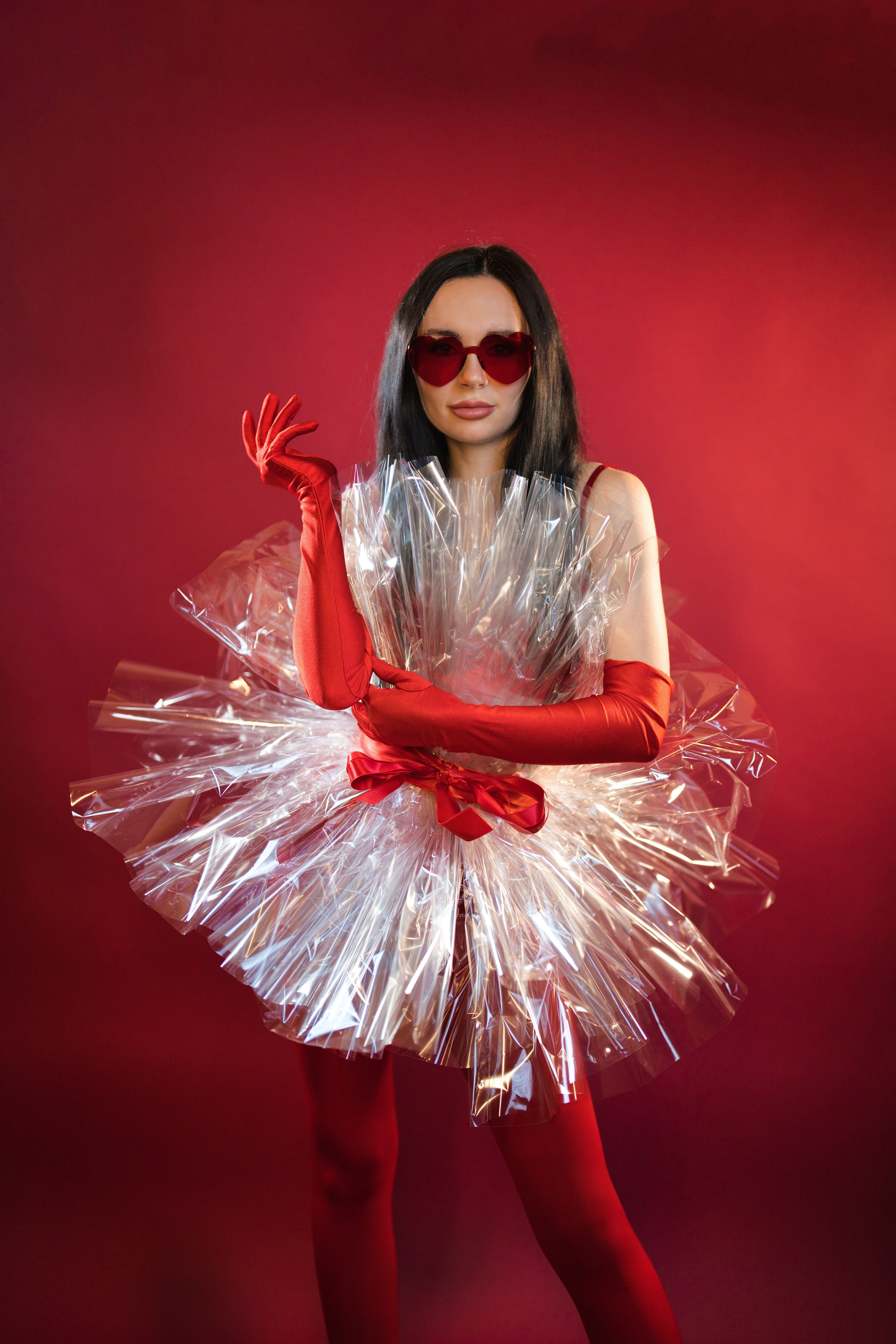 Frau posiert seitlich vor einem bordeauxroten Hintergrund.