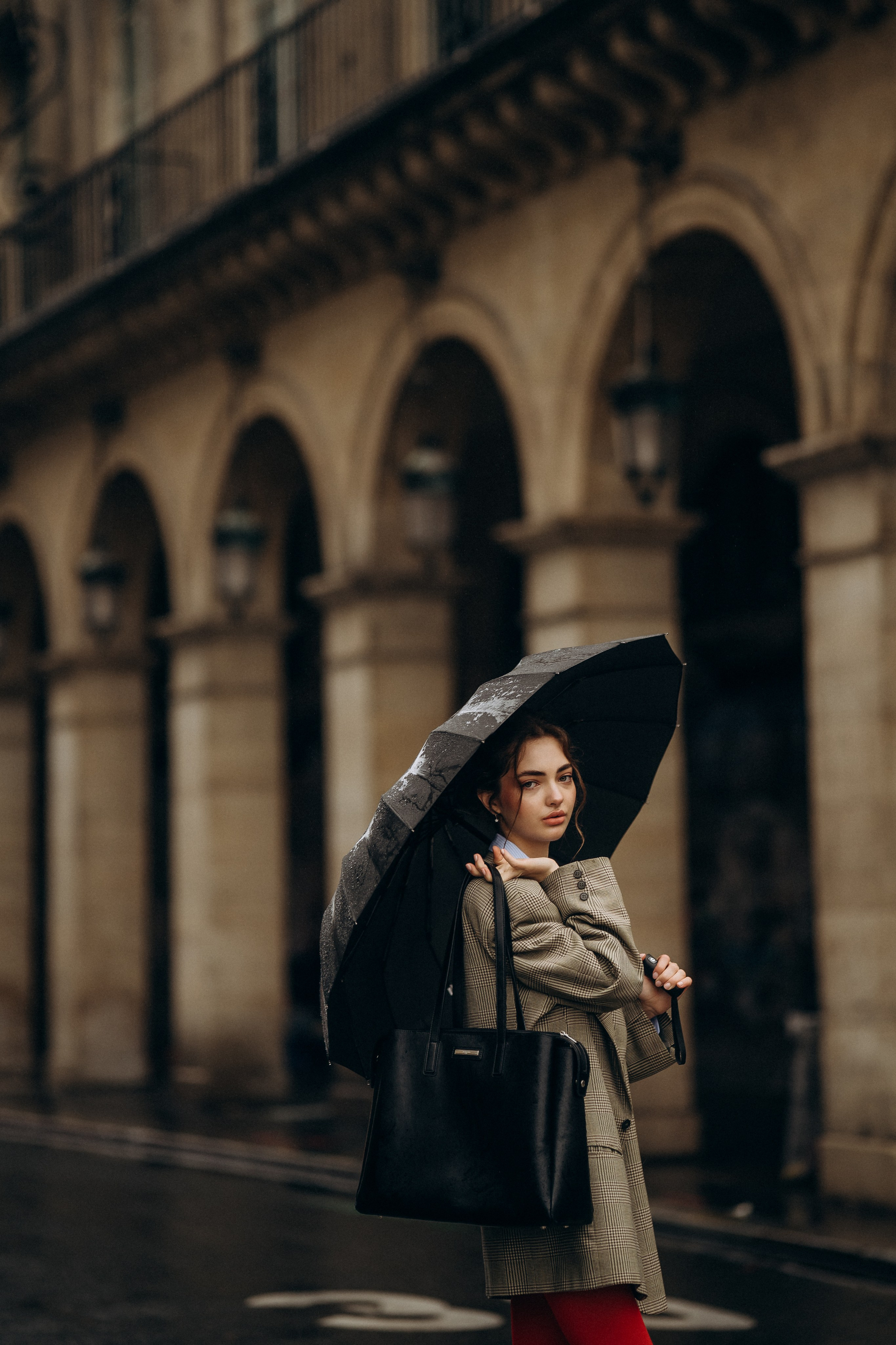 Woman walking the streets of Paris in the rain.