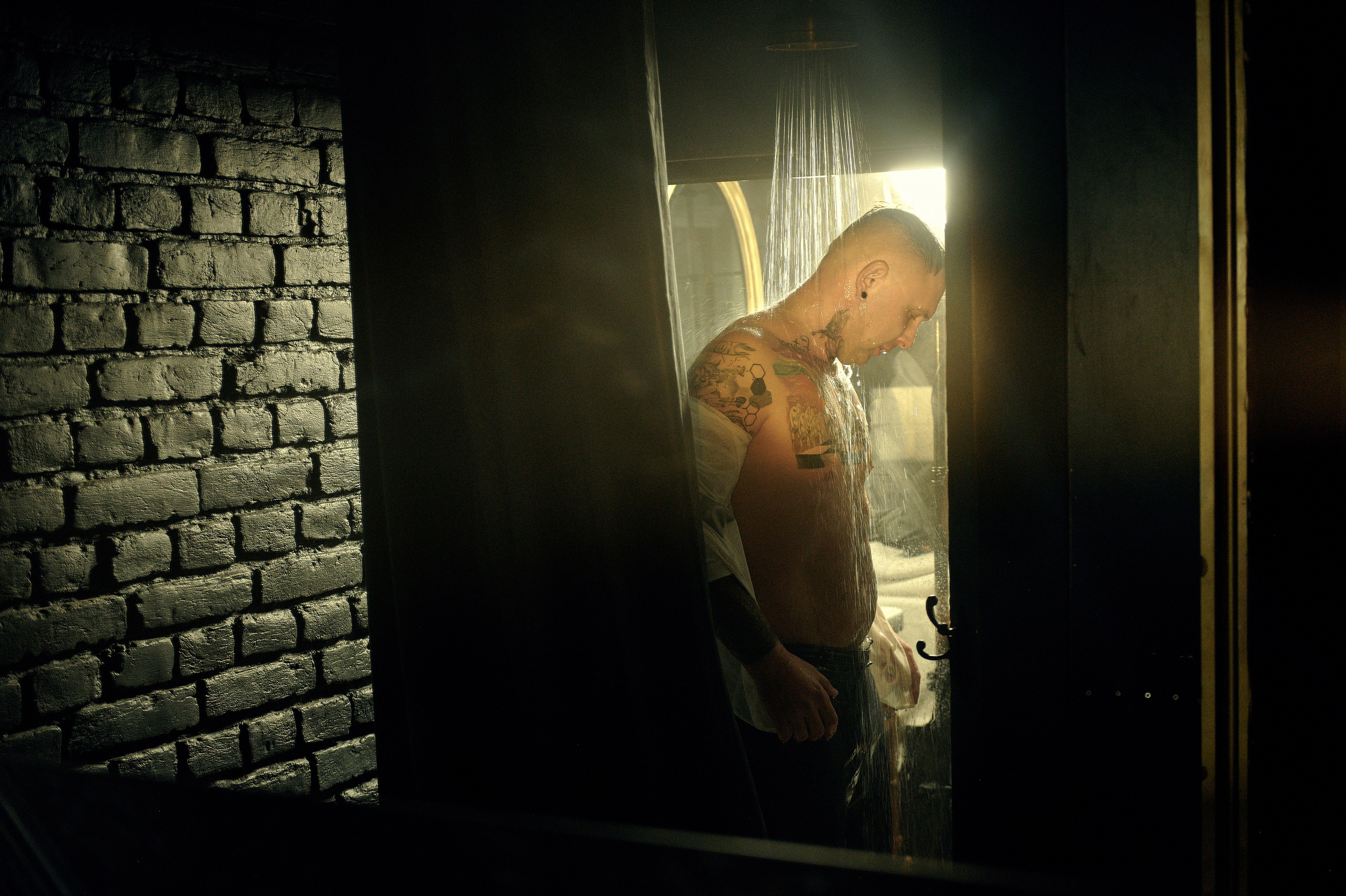 Stylowe wnętrze łazienki z wanną i widokiem na mężczyznę pod prysznicem