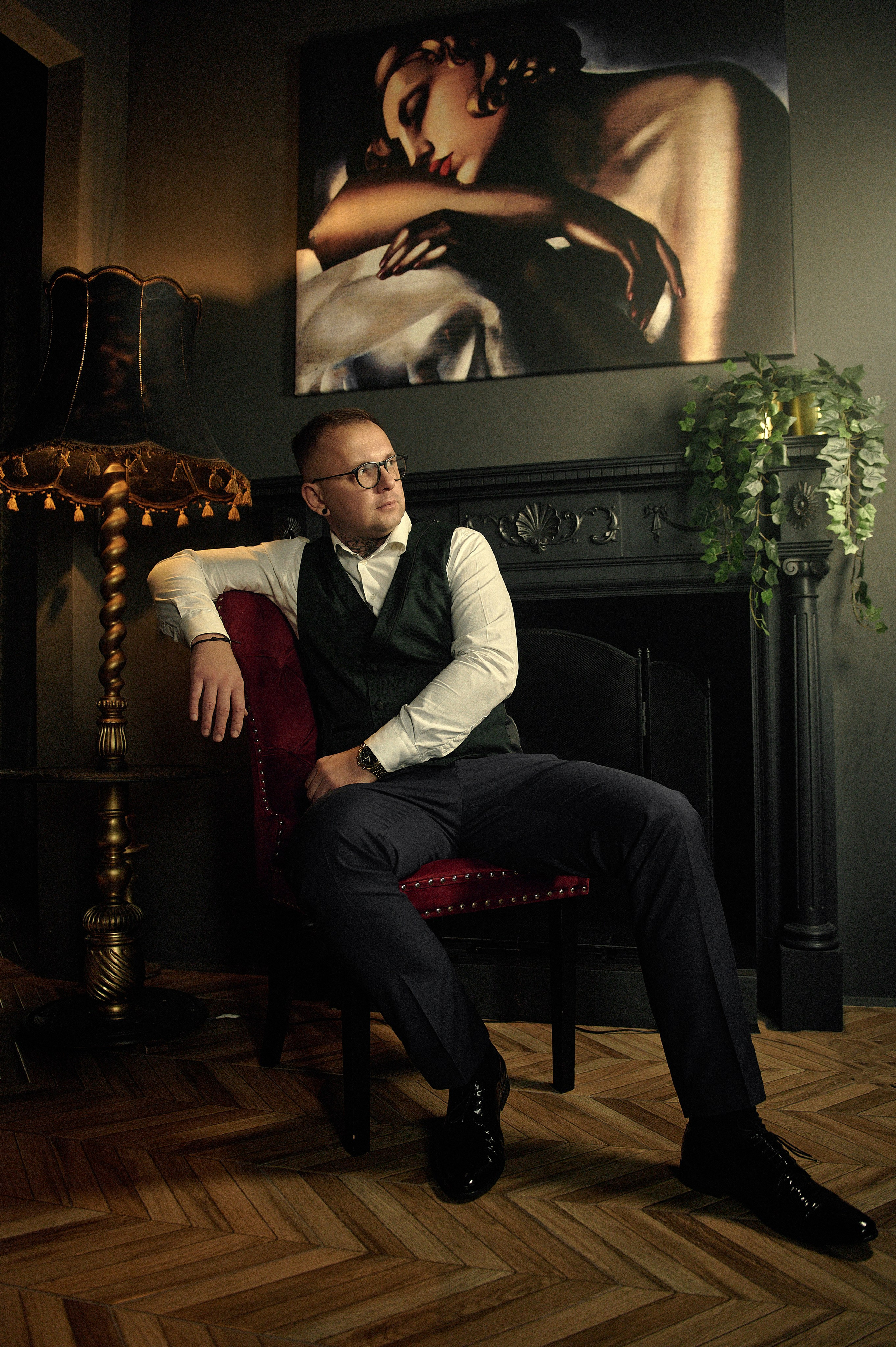 Mężczyzna w stylizacji retro przy kominku, melancholijny nastrój, elegancki wystrój, sesja wizerunkowa w Lublinie
