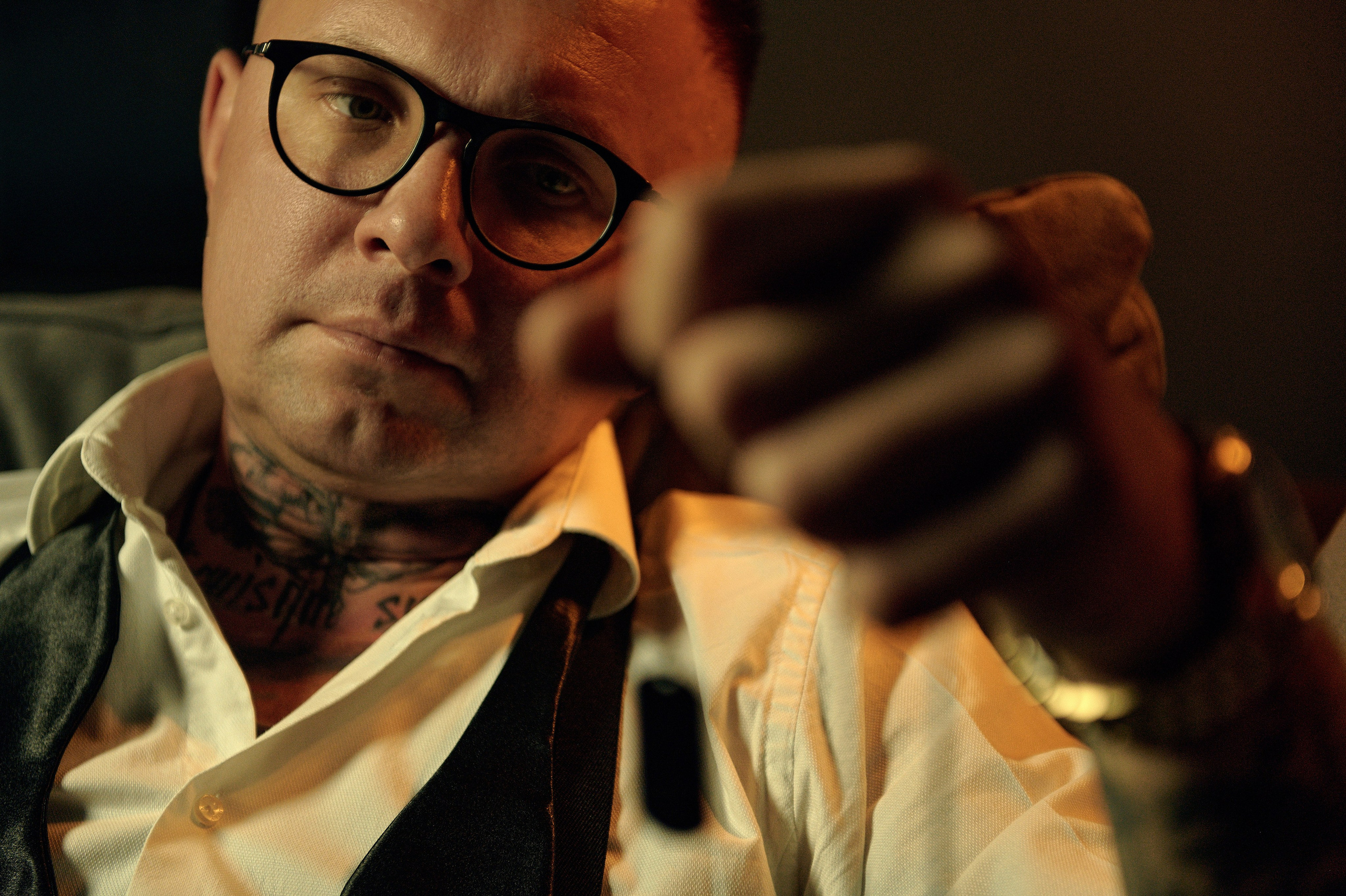 Zbliżenie na twarz mężczyzny trzymającego naszyjnik – spojrzenie w kamerę, intymna atmosfera