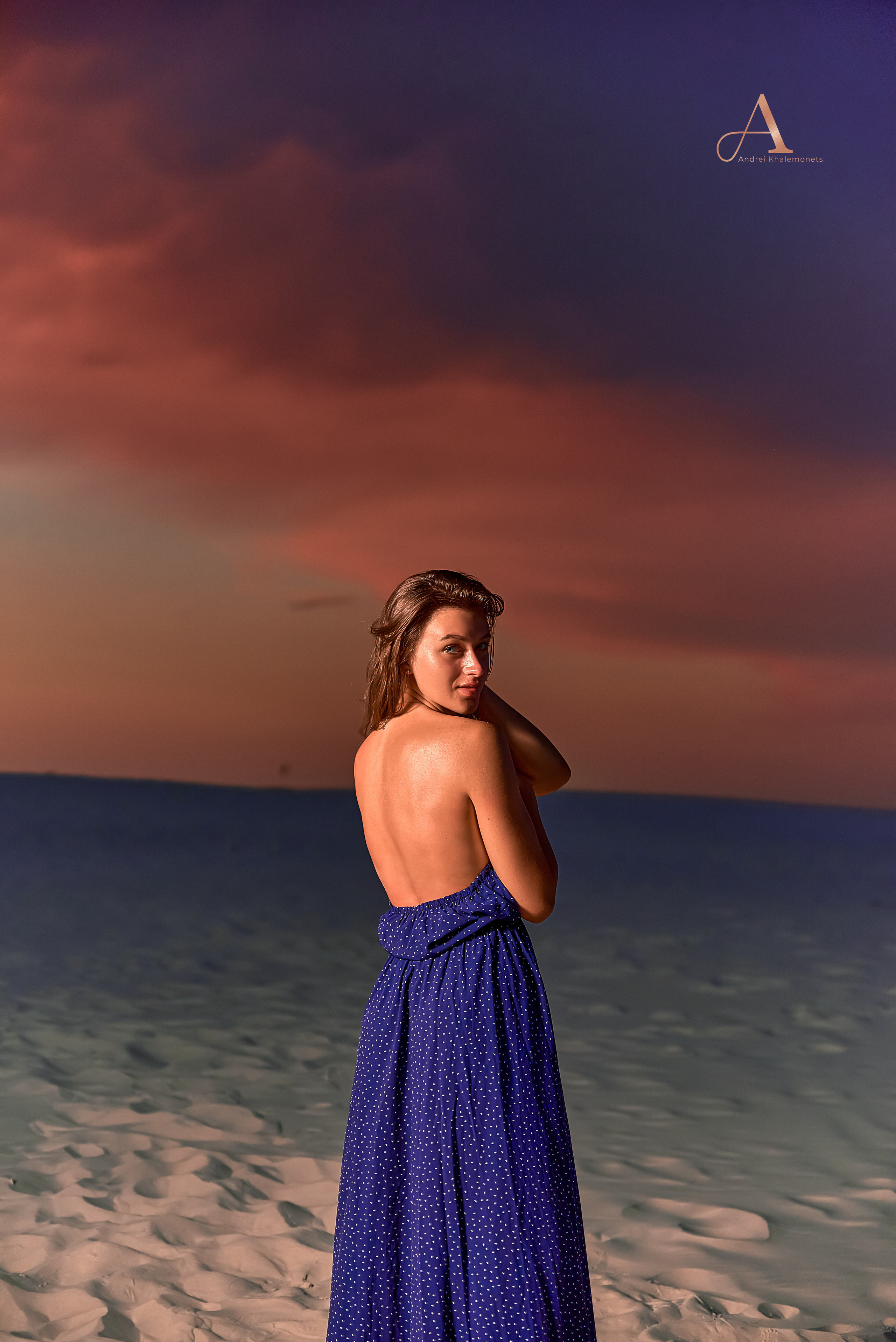 Девушка в синем платье оголяет плечи и спину, фотосессия на закате в пустыне.