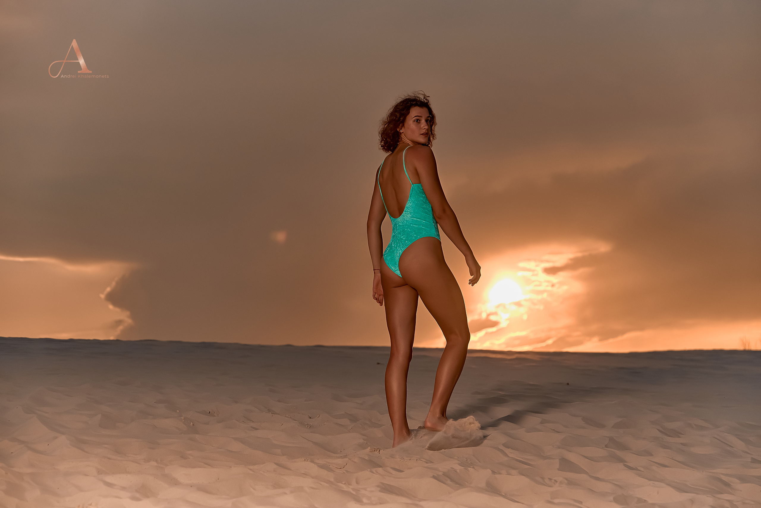 Фотопрогулка красивой девушки в купальнике в песчаной пустыне на закате.