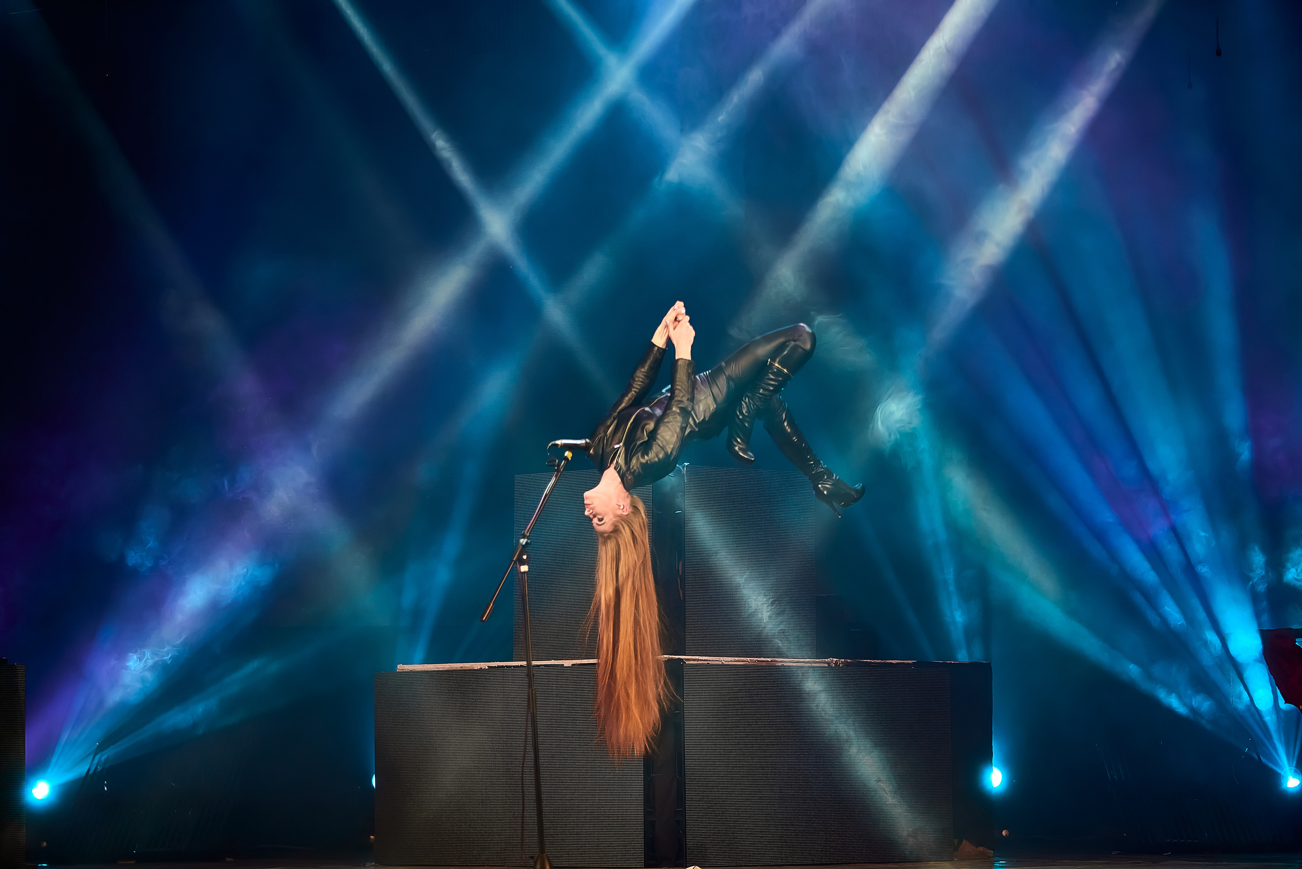 Девушка парит в воздухе на сцене театра в лучах прожектооров.