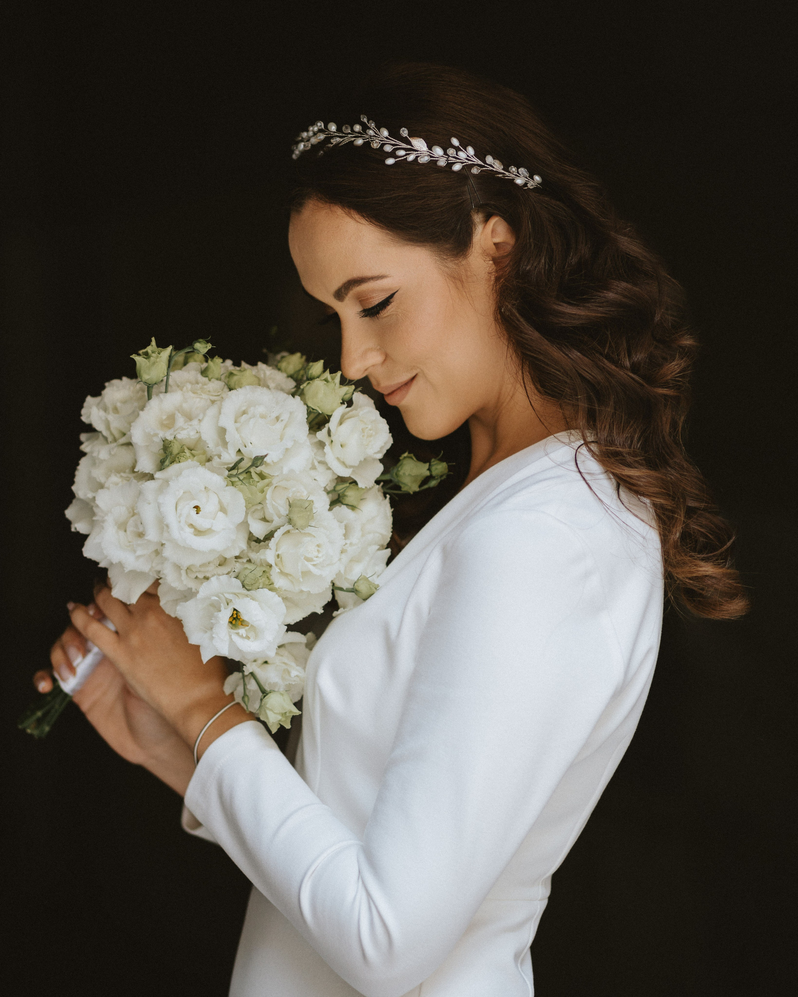 “The bride with a bouquet of white flowers, wearing an elegant wedding ring and a hairpiece, preparing for the wedding in Venice or the Amalfi Coast.”
