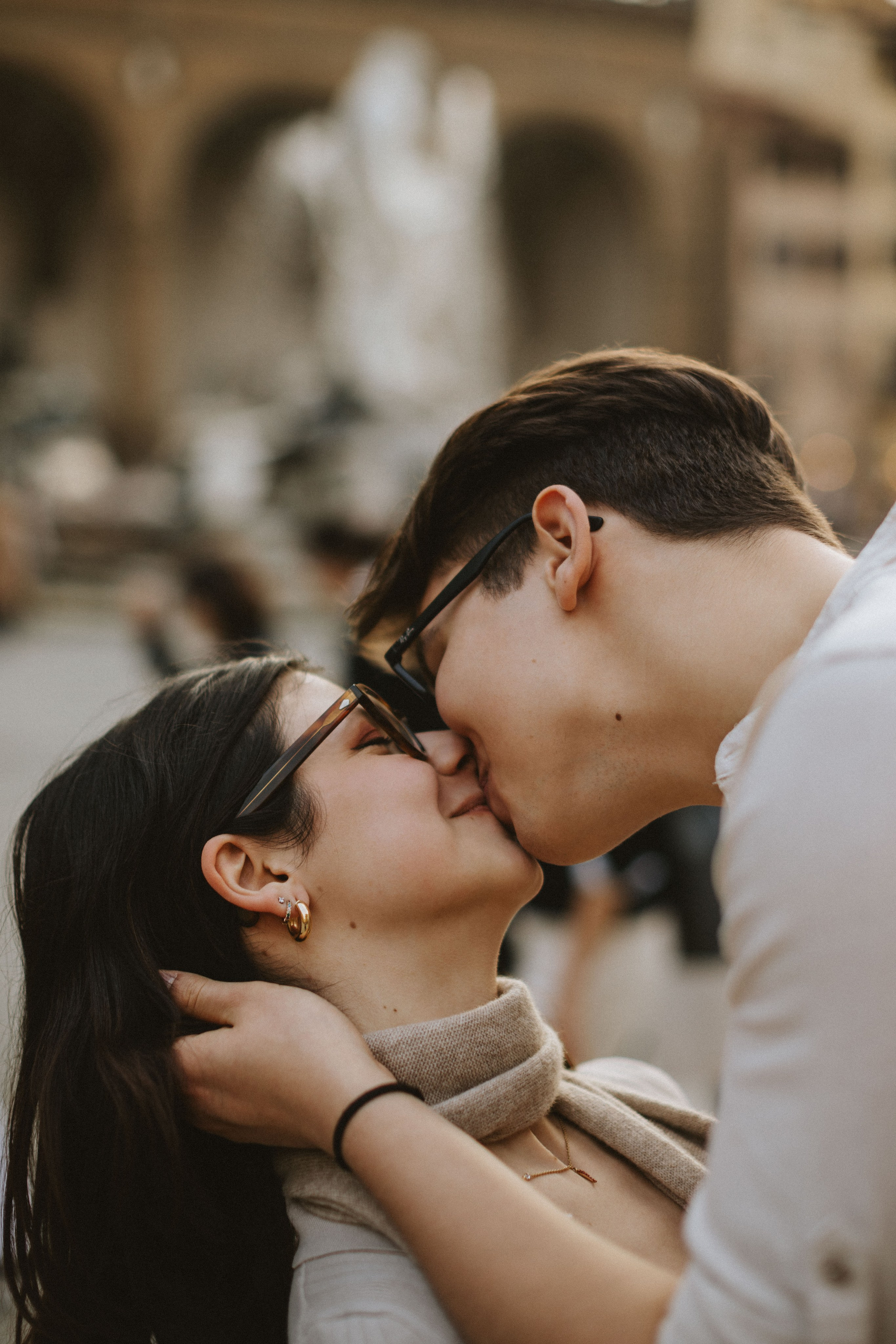 “Una coppia che si bacia davanti a una fontana sfocata, godendosi un momento romantico”.