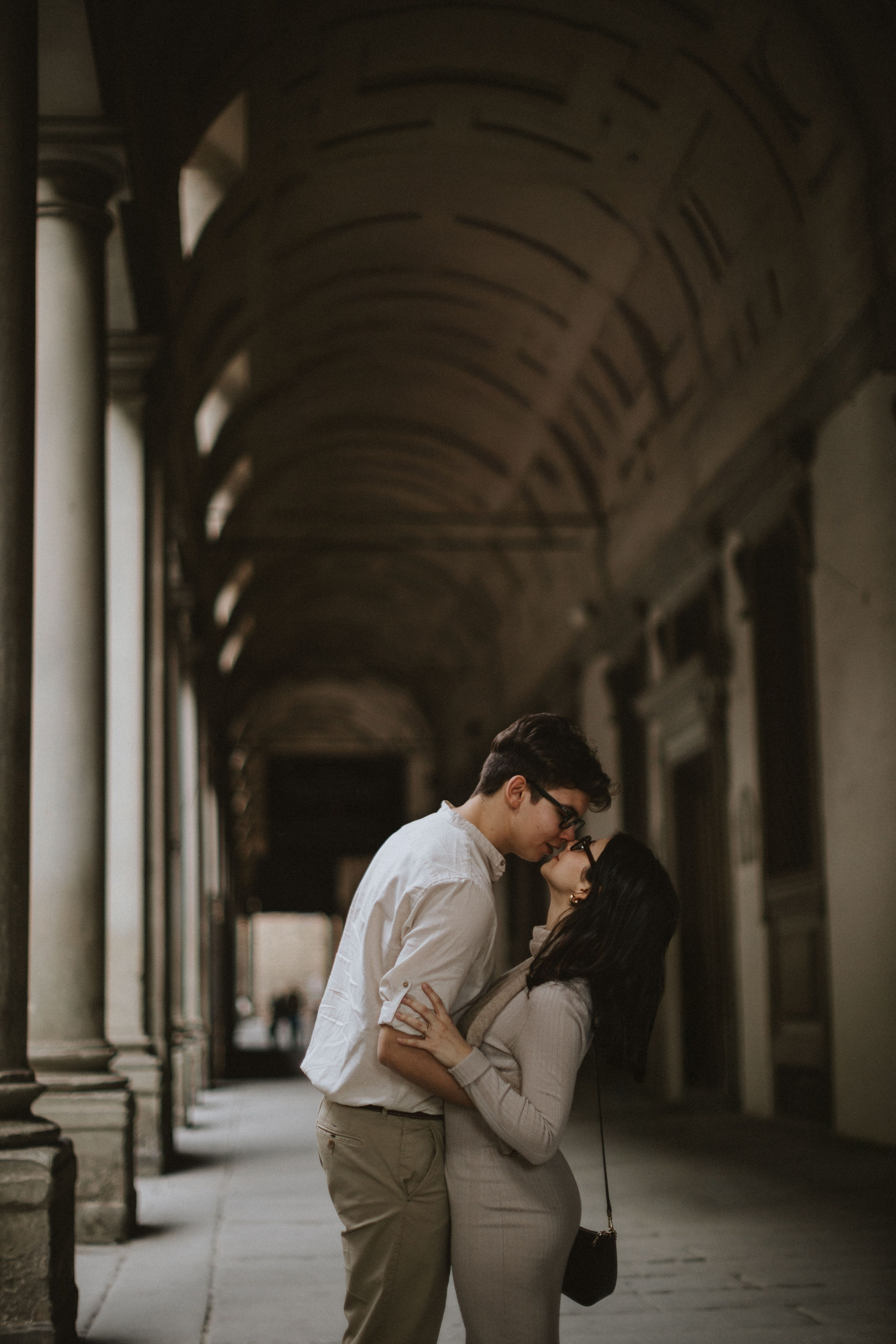 “Una coppia che si bacia sotto un bellissimo arco, persa in un momento romantico”.