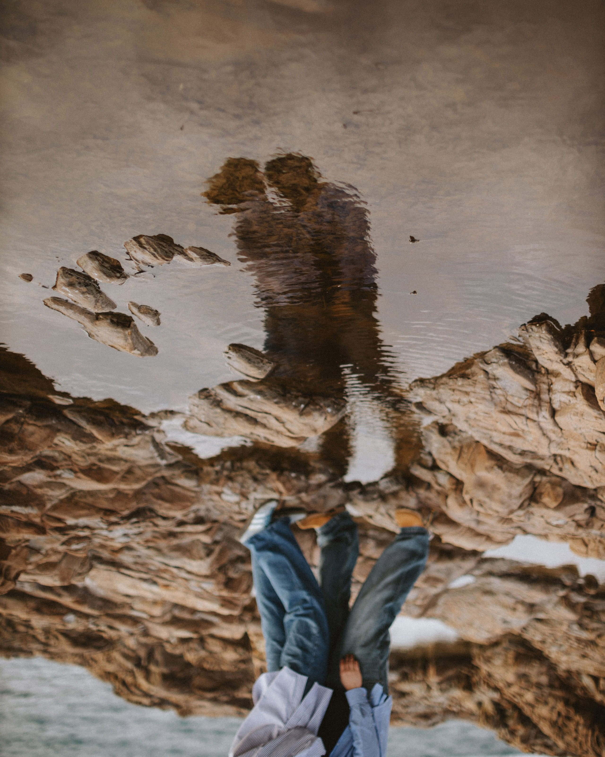 “The couple kisses, their reflection in the water creates a romantic and artistic effect.”