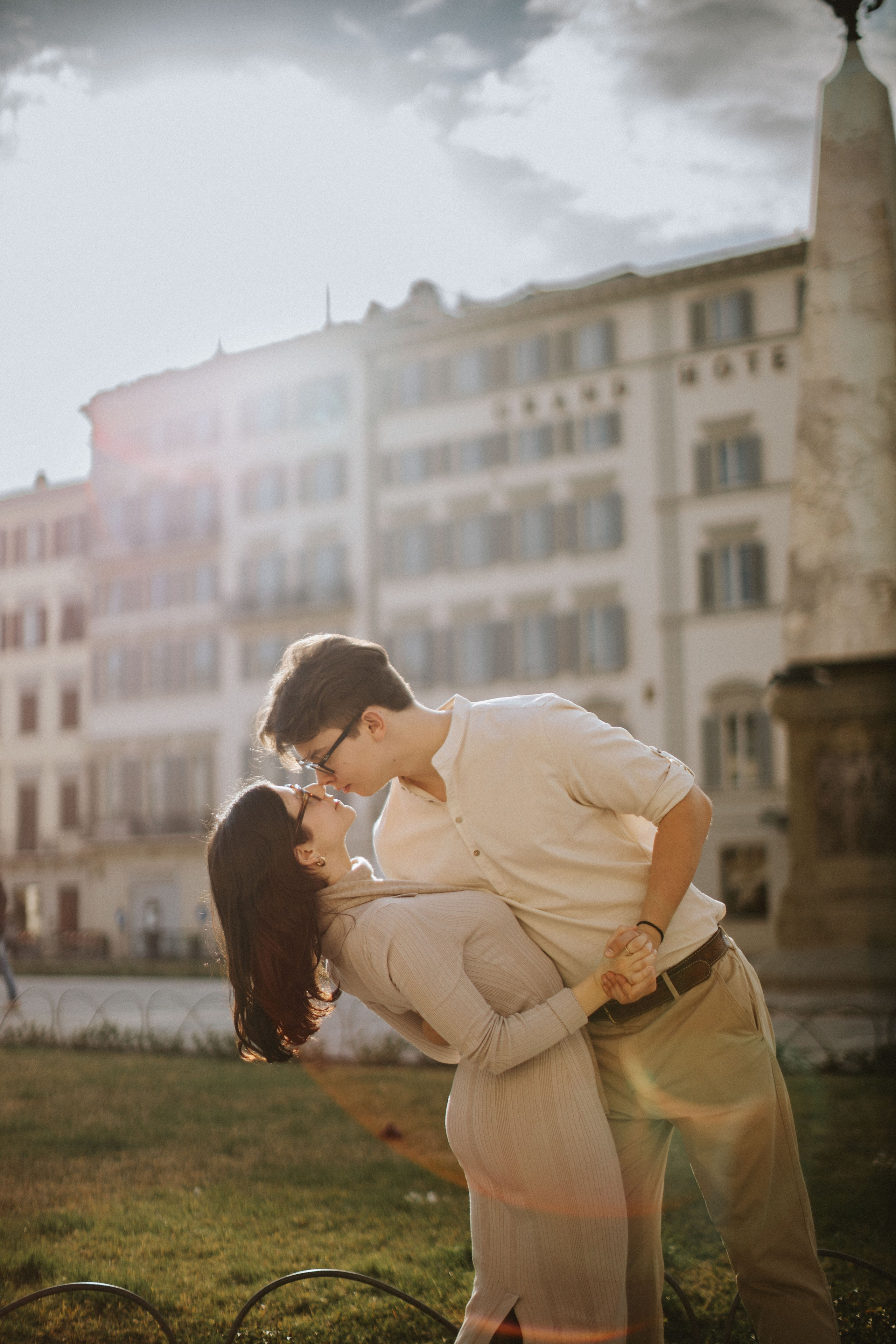 “Una coppia che condivide un momento romantico mentre balla per le strade di Firenze, sfondo illuminato dal sole”.