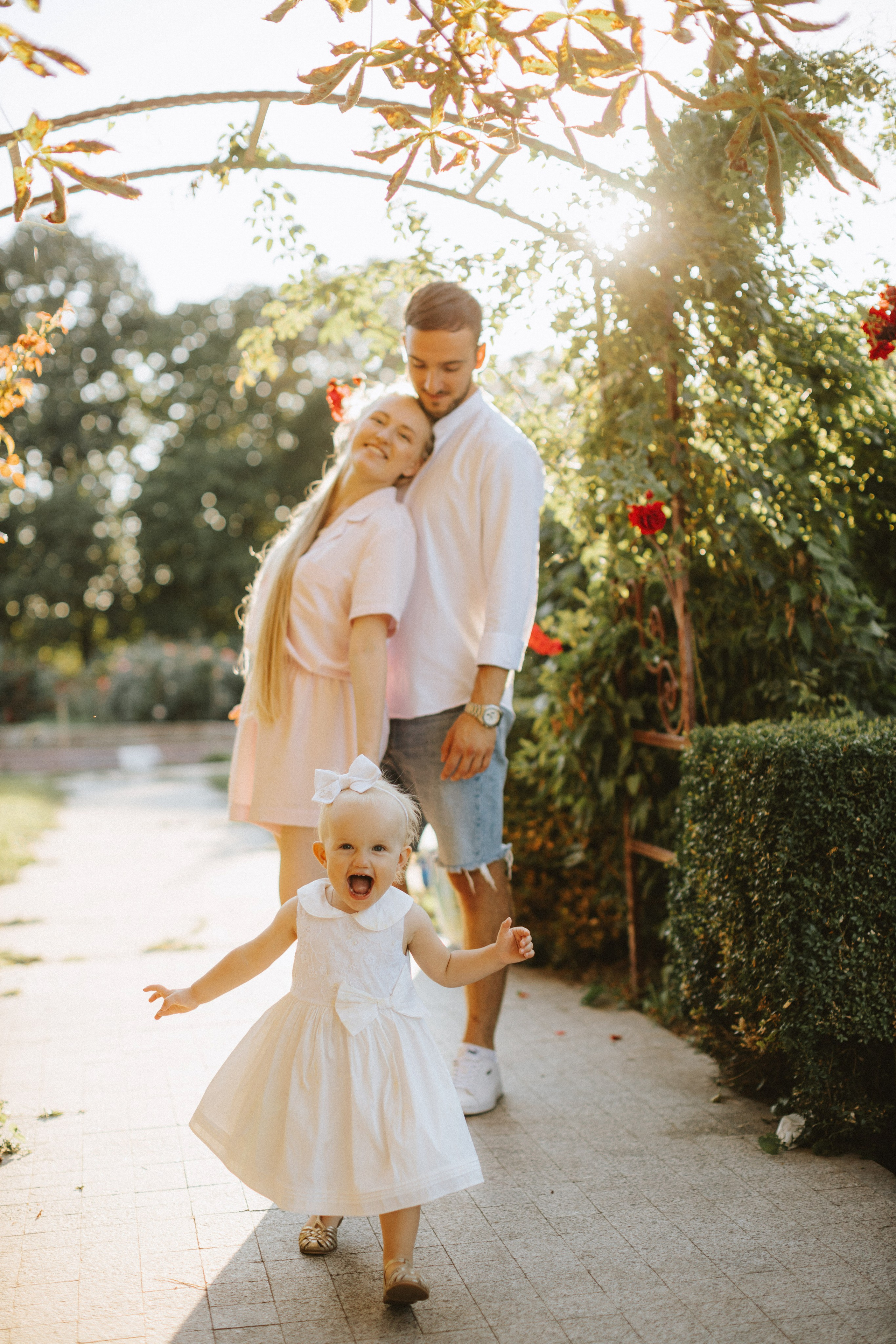 “Una famiglia che si gode un picnic nel parco, con il padre che mette un cappello al suo bambino sorridente. La madre siede vicino e la scena è piena di coperte, peluche e cibo, il tutto illuminato dalla luce soffusa del sole”.
