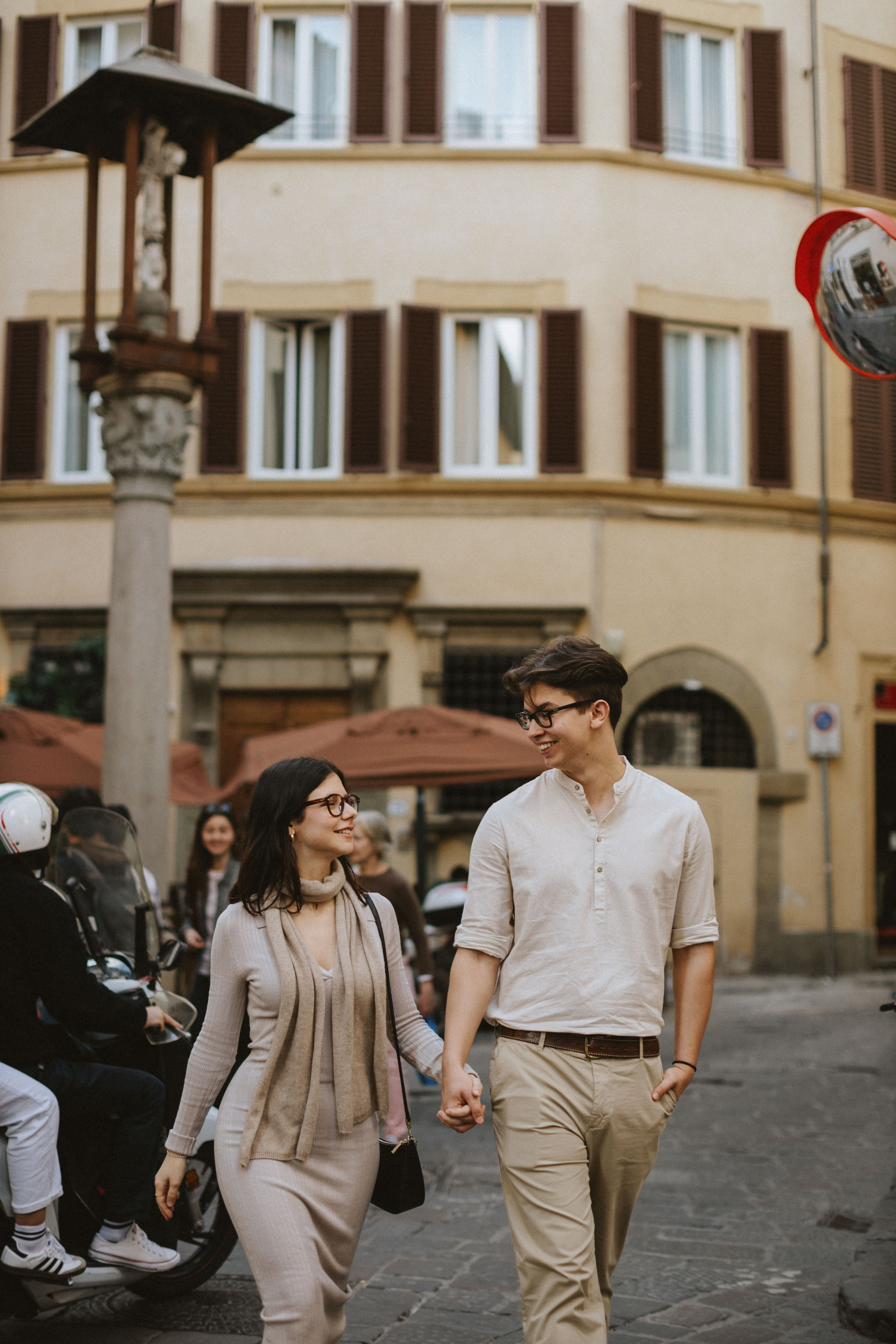 “Coppia che cammina mano nella mano per le strade della città, godendosi il tempo insieme”.