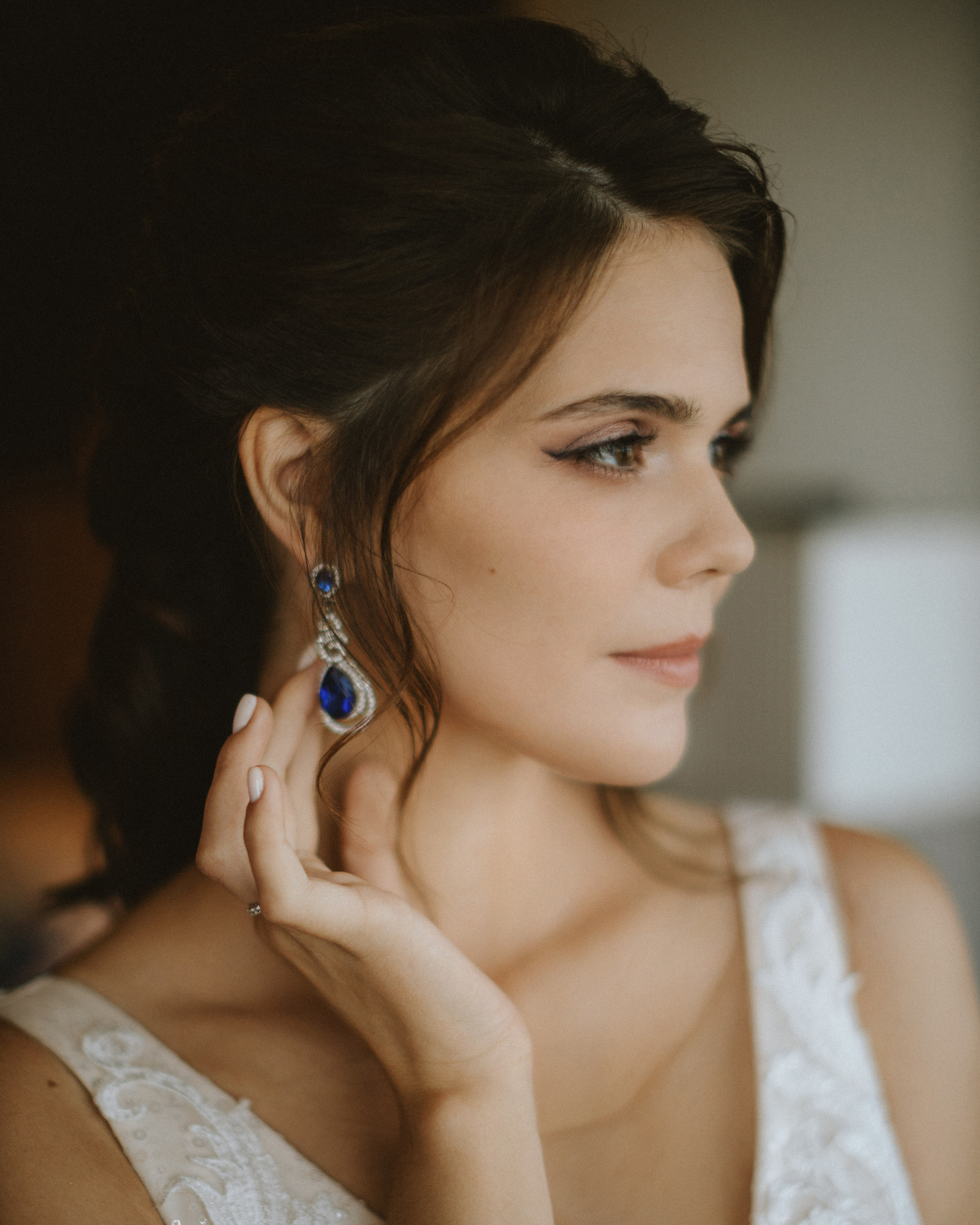 “The bride with elegant earrings and wedding makeup, getting ready for the wedding, a wedding in one of Italy’s fashionable cities, such as Milan or Rome.”