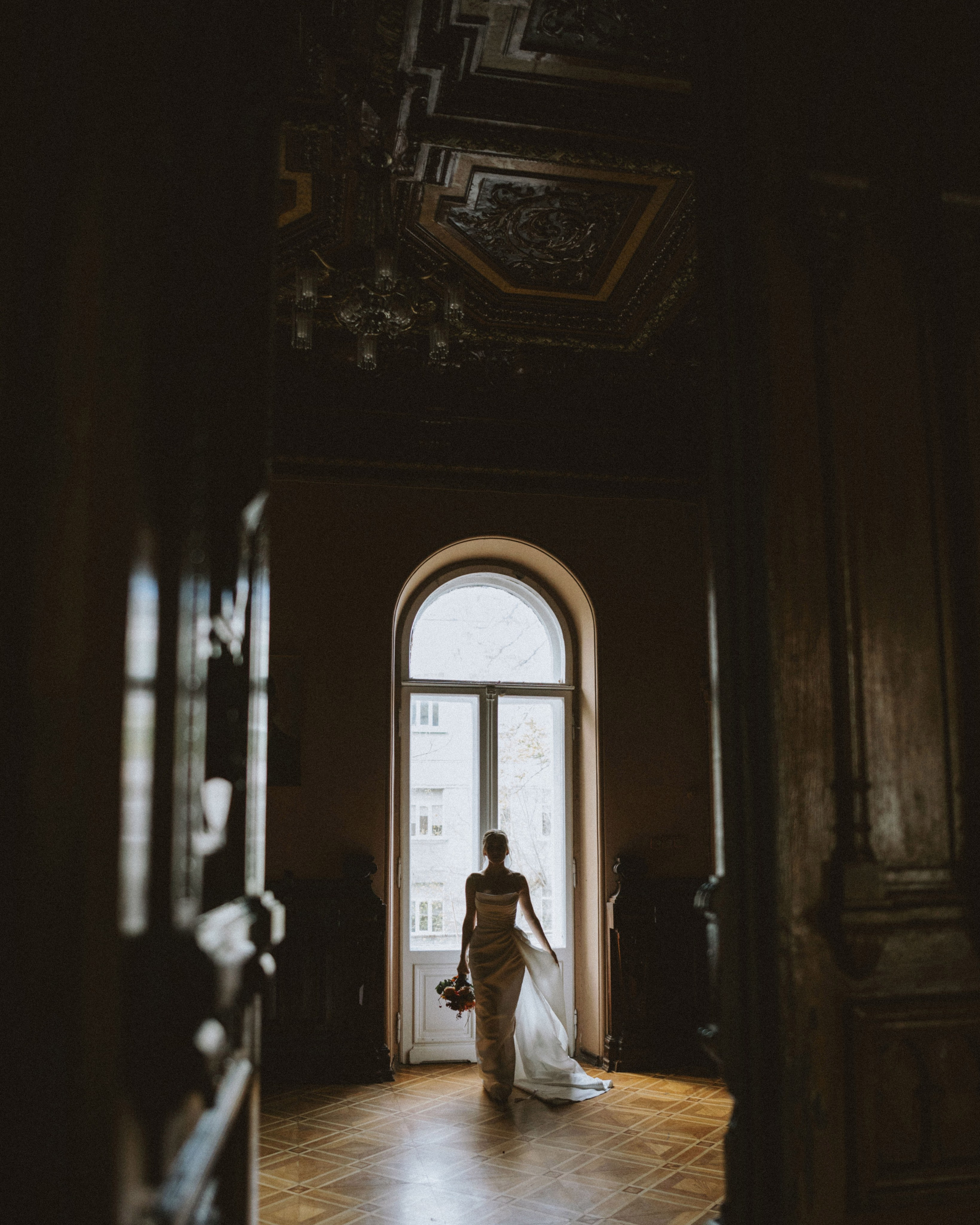 “The bride in a wedding dress with a bouquet, walking through a historic room, a wedding in Venice or Sardinia.”