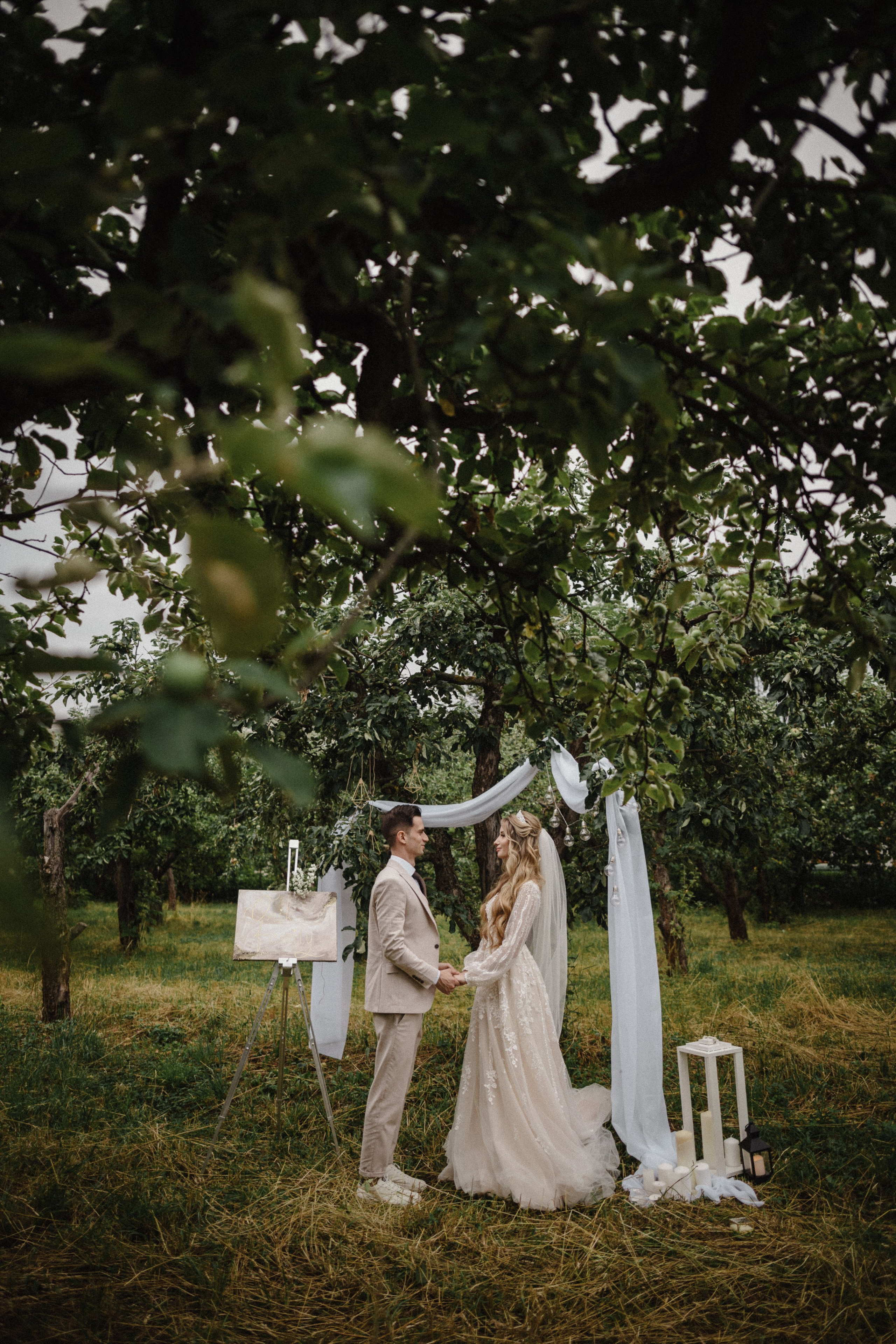 Bride and groom sharing intimate moment in apple orchard ceremony